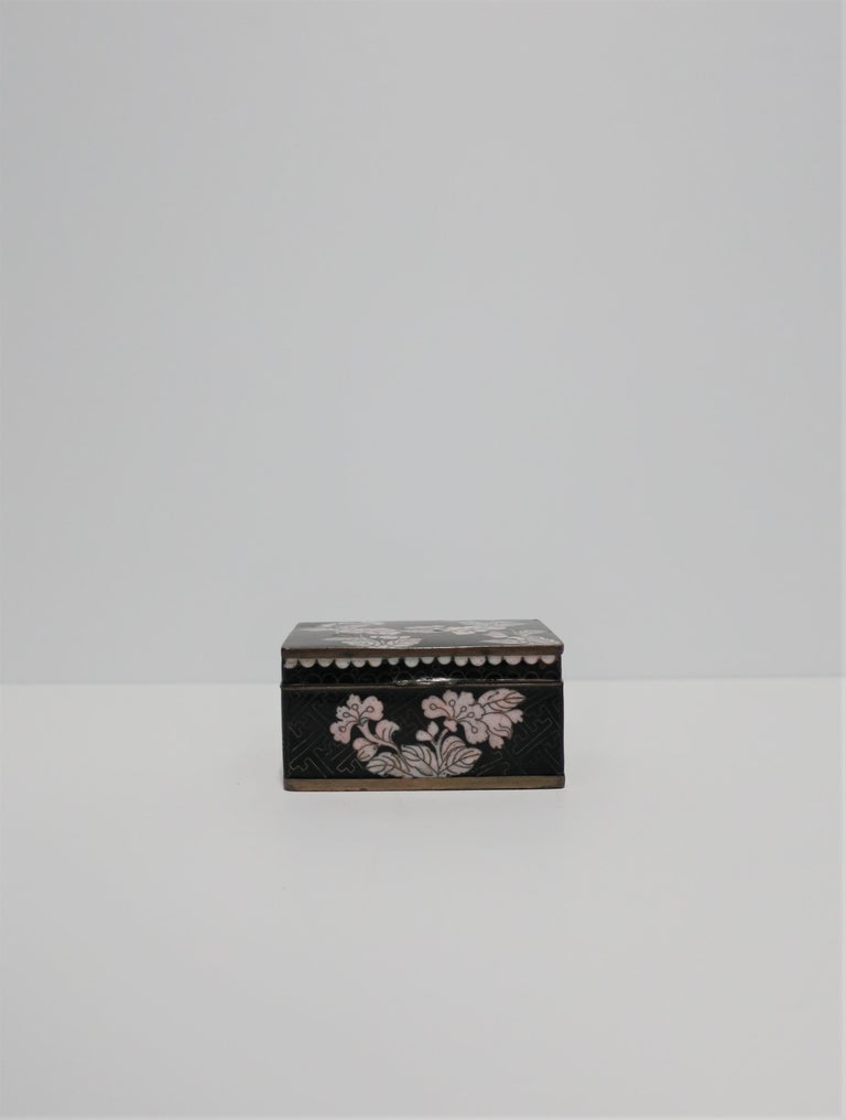 A beautiful black and white Chinese cloisonné enamel and brass box, circa early 20th century, China. Box has black background and white enamel with flowers and leaves. A 20th century marking 