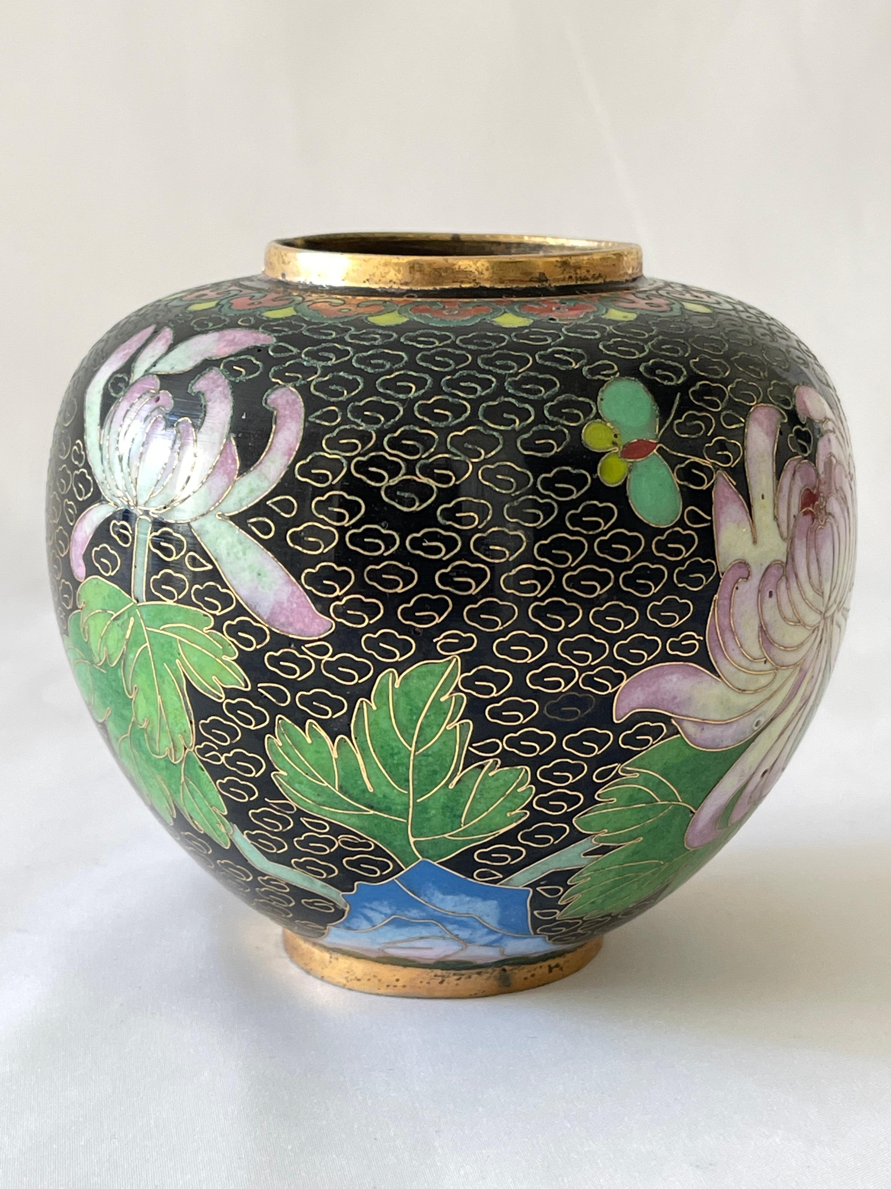 Vase chinois en forme de pot à gingembre en émail noir cloisonné et laiton avec des fleurs de chrysanthème, des fleurs de cornouiller et un papillon et de belles couleurs riches. 
Fabriqué à la main en laiton massif.