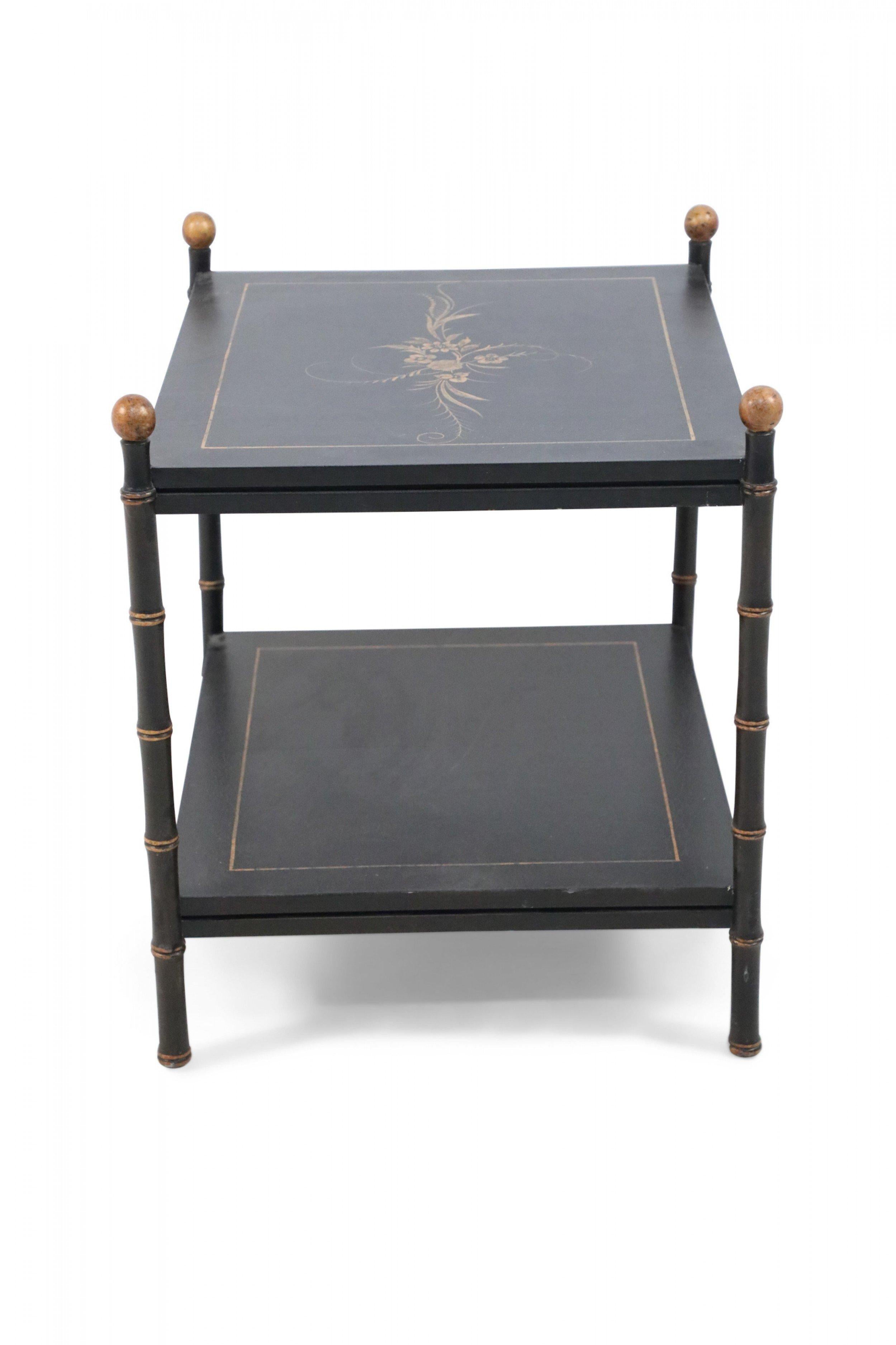 Table d'appoint chinoise noire à deux étages soutenue par des pieds en faux bambou rehaussés d'or, et peinte de bordures dorées et d'un motif floral décorant l'étagère supérieure.
 