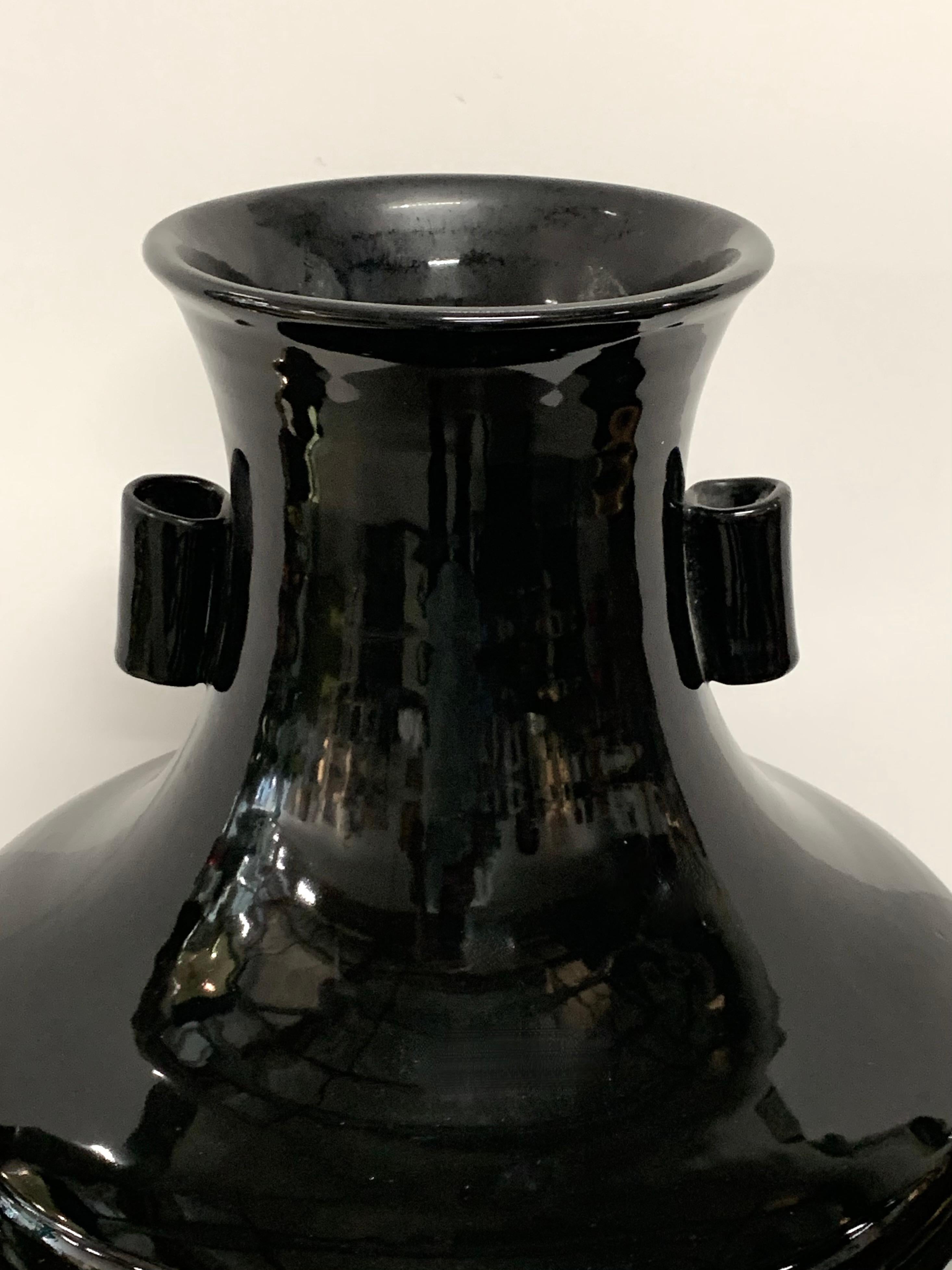 Un elegante vaso cinese in ceramica smaltata nera con manici. L'abbiamo acquistata da una bella tenuta di Palm Springs. Ha un'altezza di 20 pollici e un diametro di oltre 15 pollici. Una sorta di terracotta pesante o di gres bianco. Riteniamo che