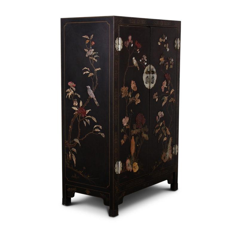 A Chinese black lacquer two-door cabinet, embellished with a variety of flora and fauna depictions carved of semi-precious hard-stones in a variety of colors, circa 1930-1940.



