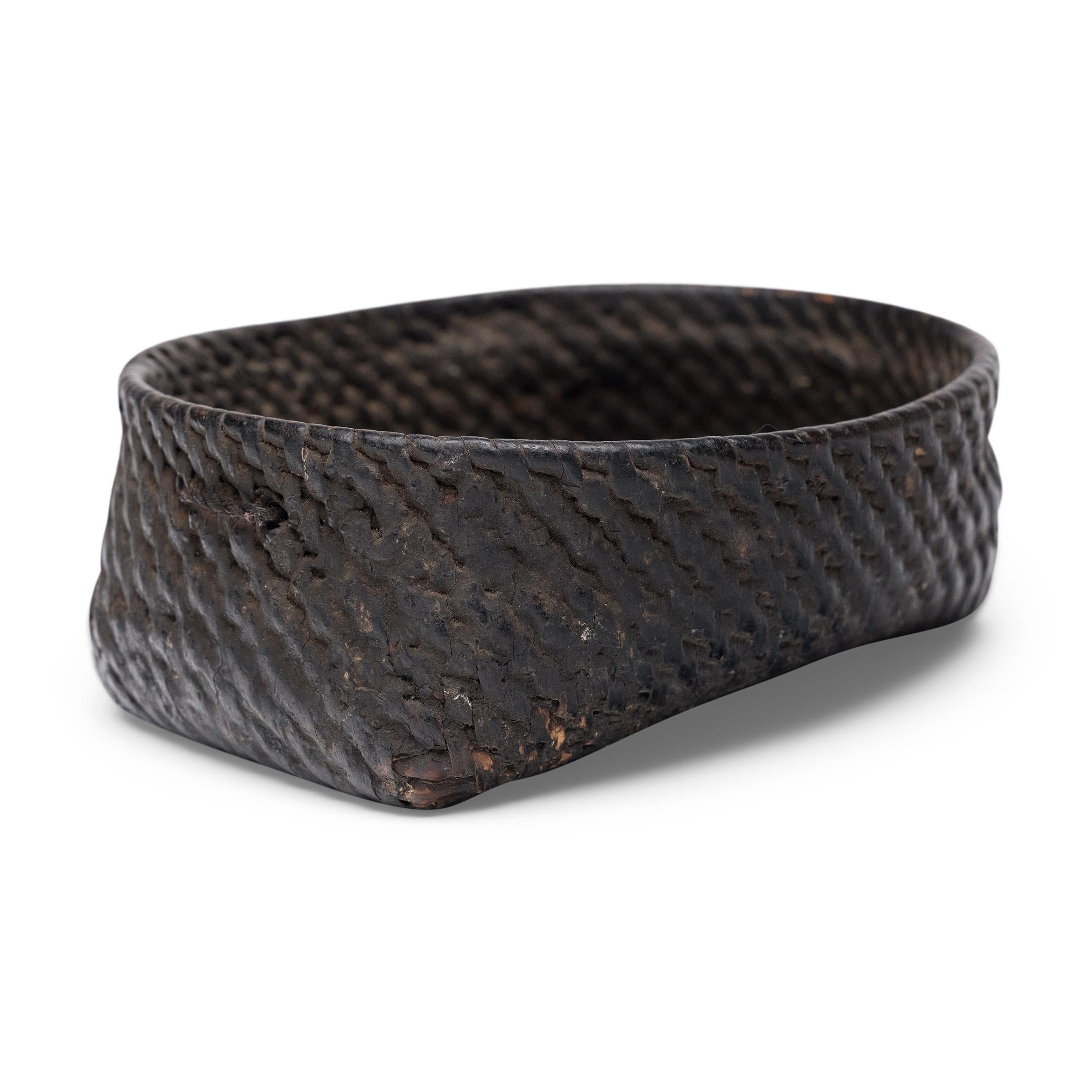 Questo piccolo vassoio intrecciato dell'inizio del XX secolo celebra la bella semplicità di un oggetto intrecciato a mano. Il piatto è strettamente intrecciato di bambù in forma quadrata e rotonda e rifinito con uno spesso strato di thayo, una