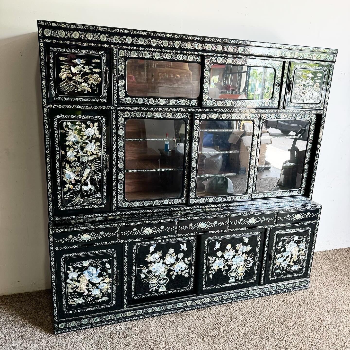 Valorizza la tua casa con questo raffinato armadietto cinese con intarsi in madreperla. Realizzato in legno laccato nero con intricati intarsi in madreperla che raffigurano delicati motivi floreali e paesaggi panoramici. Gli sportelli con ante in