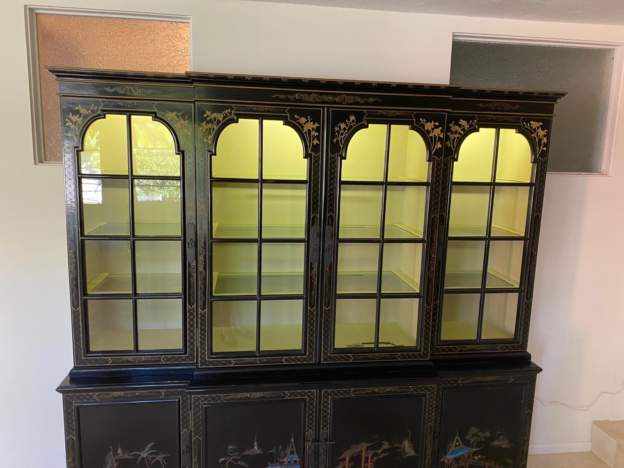 Teakwood breakfront hand painted with gold leaf breaks down into 2 pieces lighting in across top inside painted pale yellow inside having drawers in the center bottom maker J. L. George &Co., Ltd. Hong Kong.