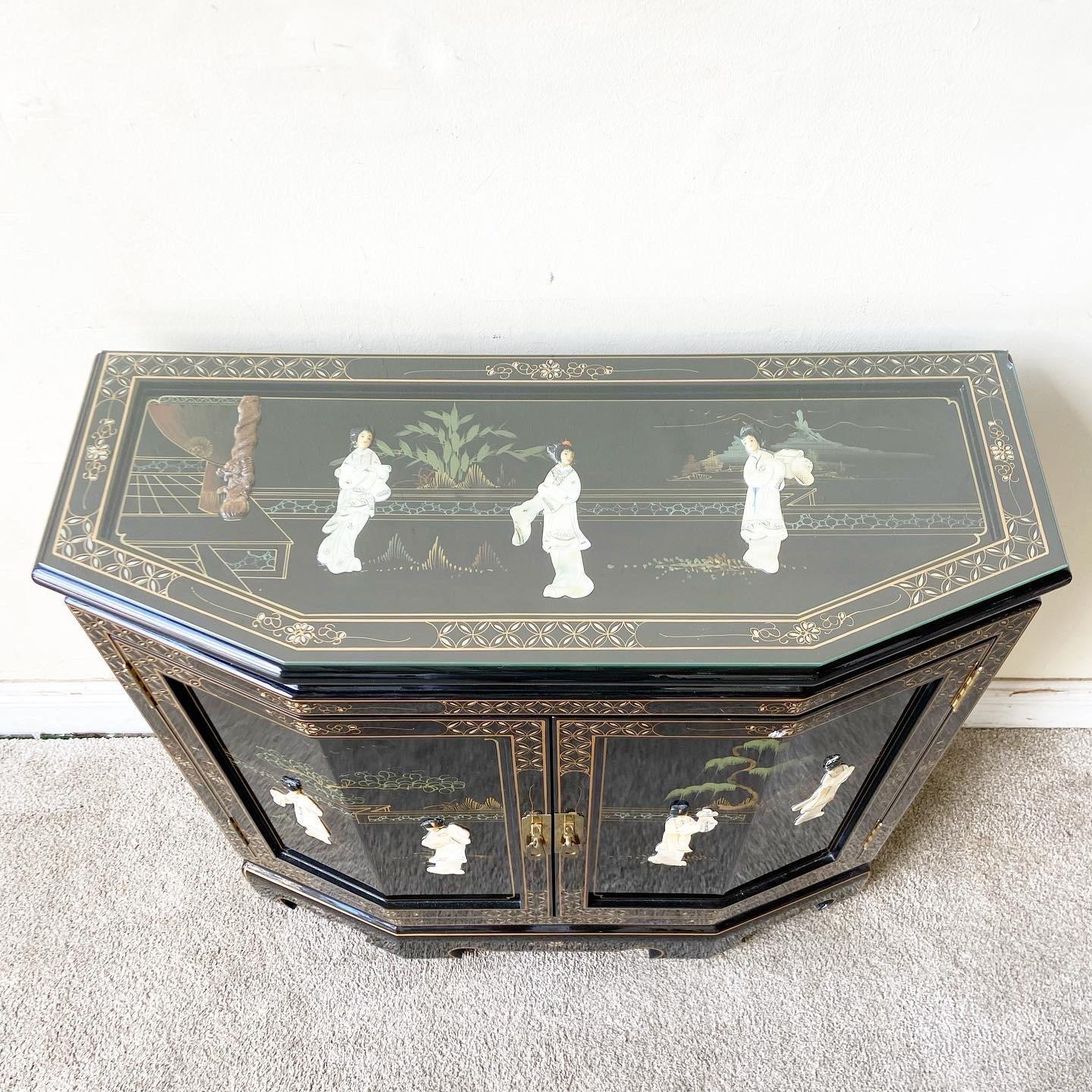 Excellent Chinese black lacquered small credenza/sideboard. Features a mother of painted with mother of pearl depiction of Chinese situations.
 