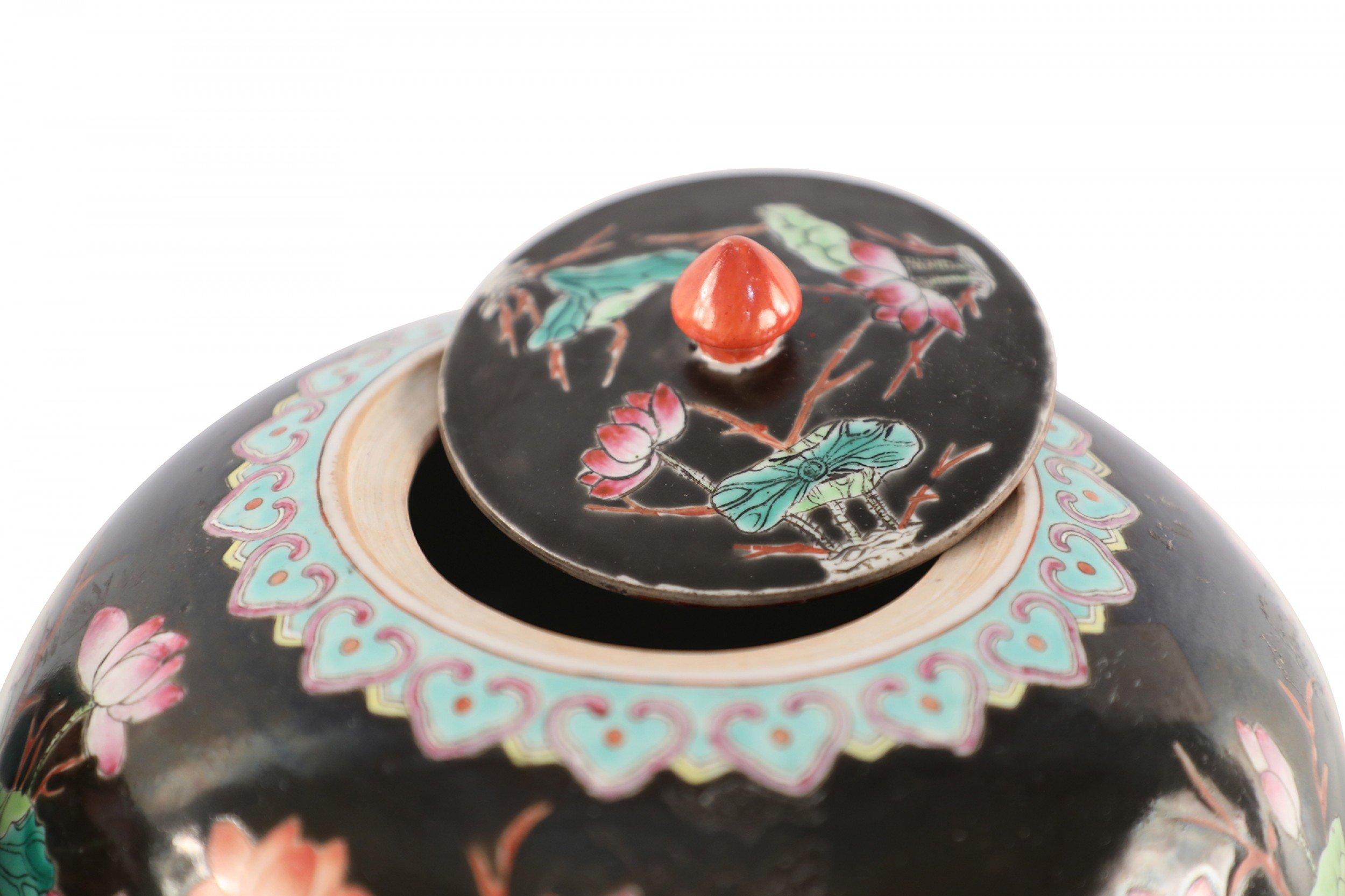 4 Chinese similar black porcelain vases painted with natural scenes depicting ducks amid florals and lily pads and geometric patterned bands at the tops and bases with finial-topped lids (vases vary slightly in size, shape and pattern) (PRICED