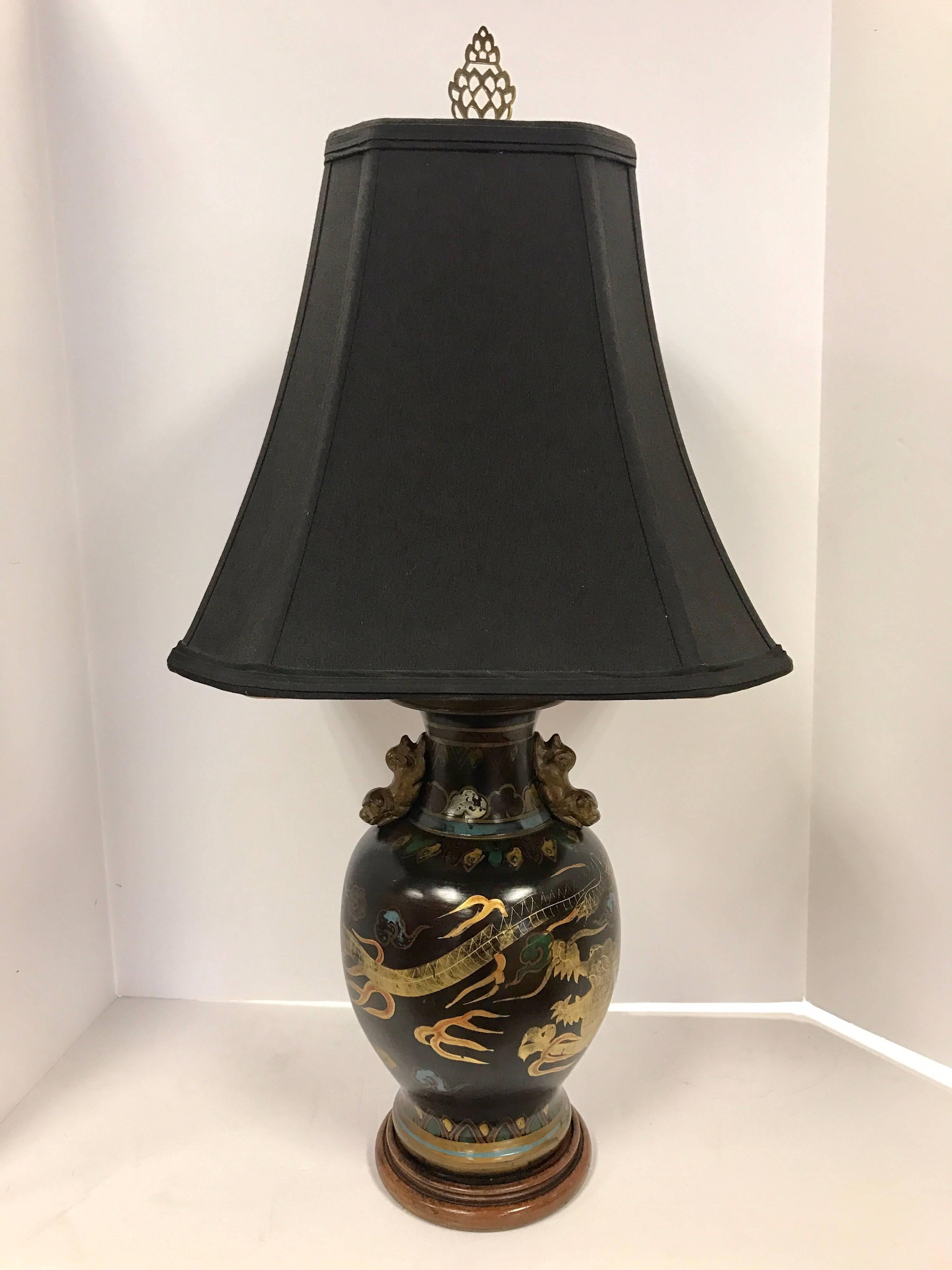 Elegant hand-painted Chinese porcelain dragon lamp with foo dogs at handles. Shade measures 14