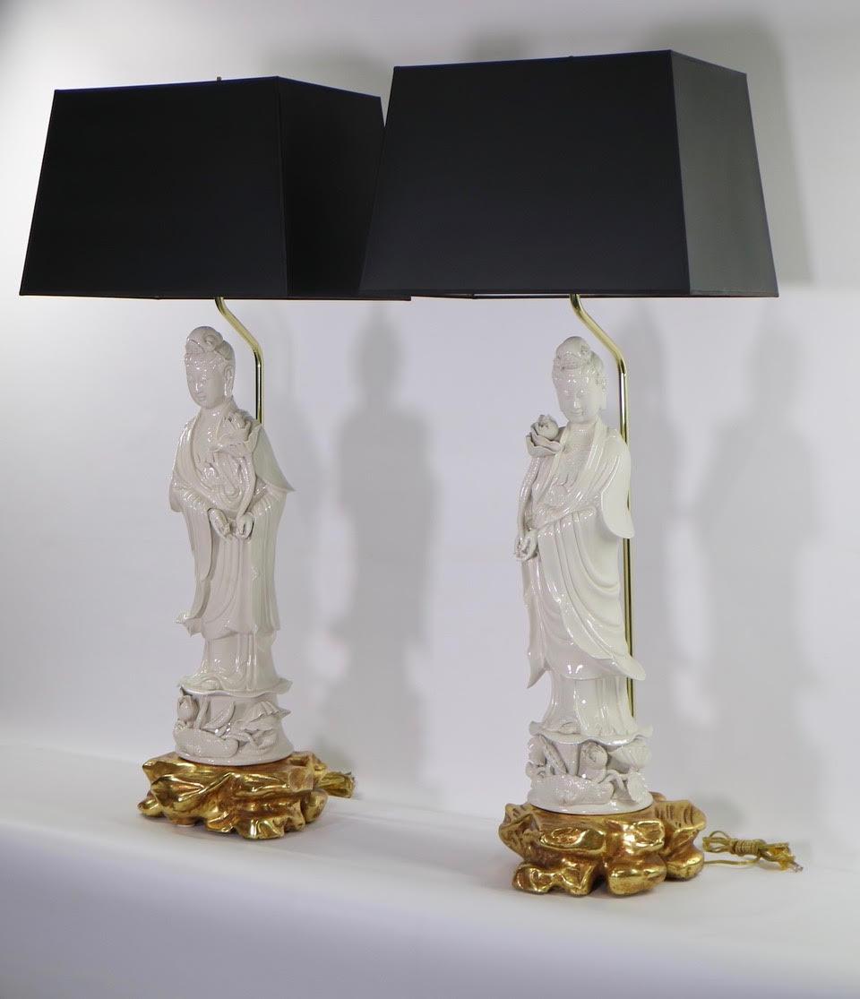 Chinese pair of large blanc de chine porcelain figures of Guanyin, mounted as table lamps. The pair sits on gilded wooden bases emulating clouds. The figures were made in the early 20th century and have removable hands. Fully restored with new