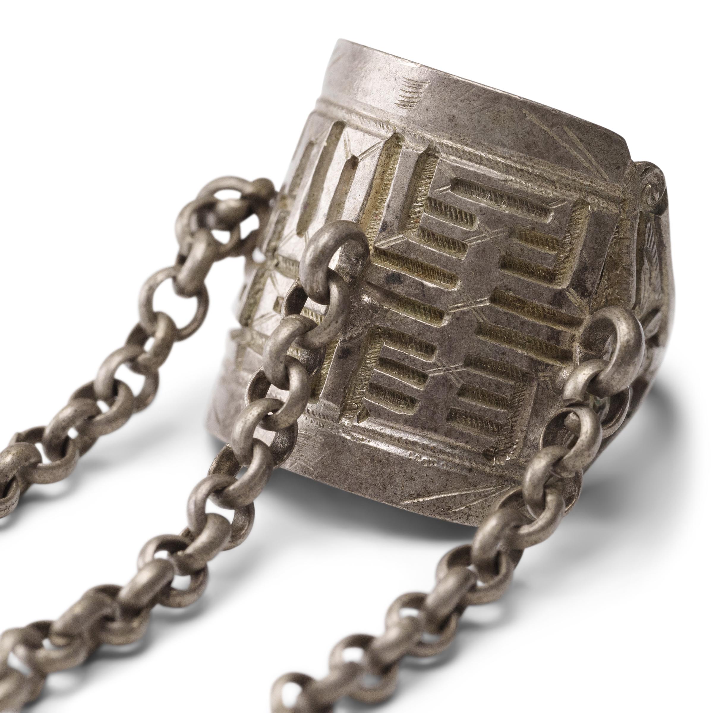 Dated to the late 19th century, this silver charm ring was crafted by the Miao peoples of Guizhou province and was believed to protect the wearer from bad luck and malevolent spirits. The ring band has a low relief design of two folk symbols