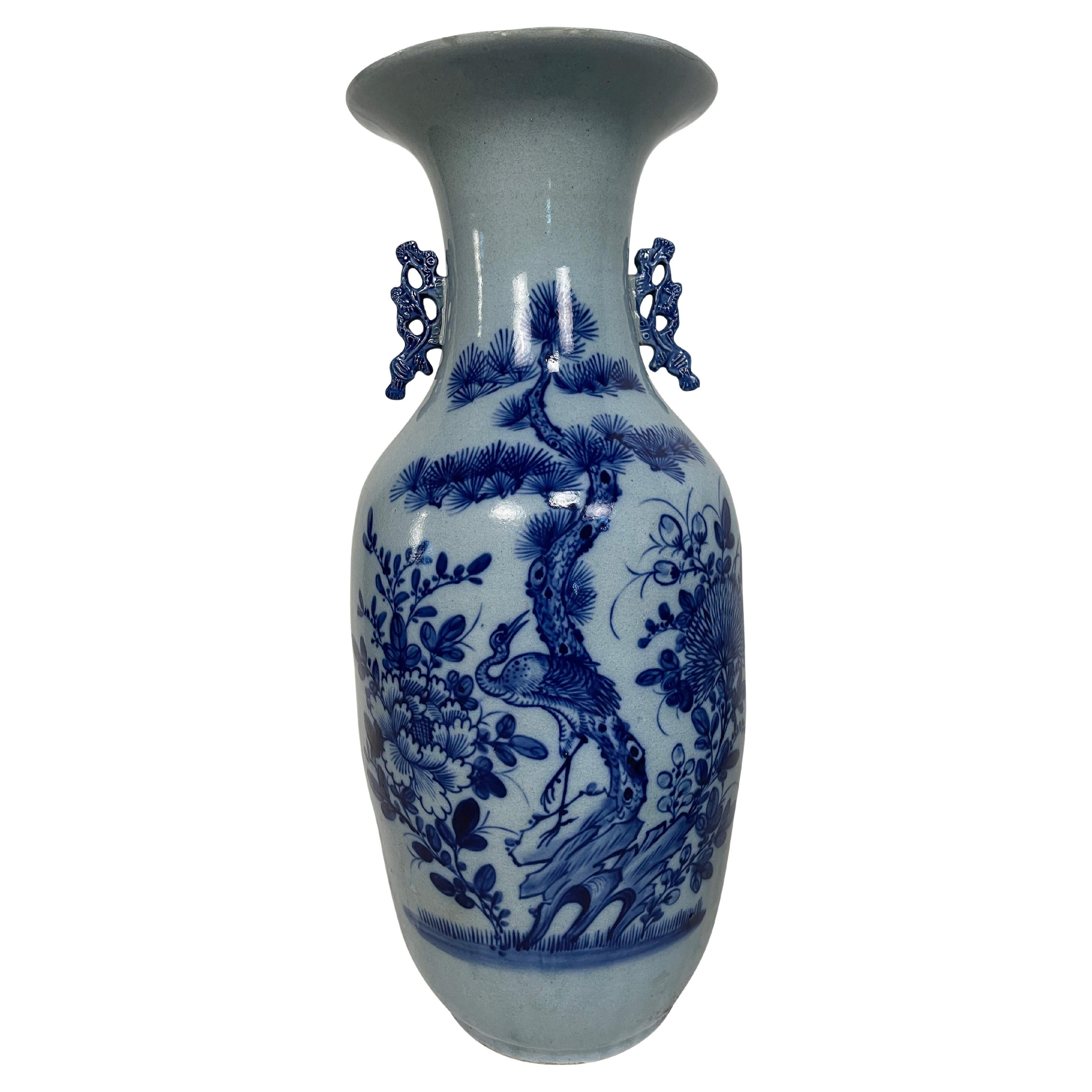 A fine antique 19th-century Chinese porcelain large baluster vase decorated with various flowers and objects in low relief and underglaze cobalt blue within a white-glazed ground. The vase has molded stylized handles in cobalt blue to either side of