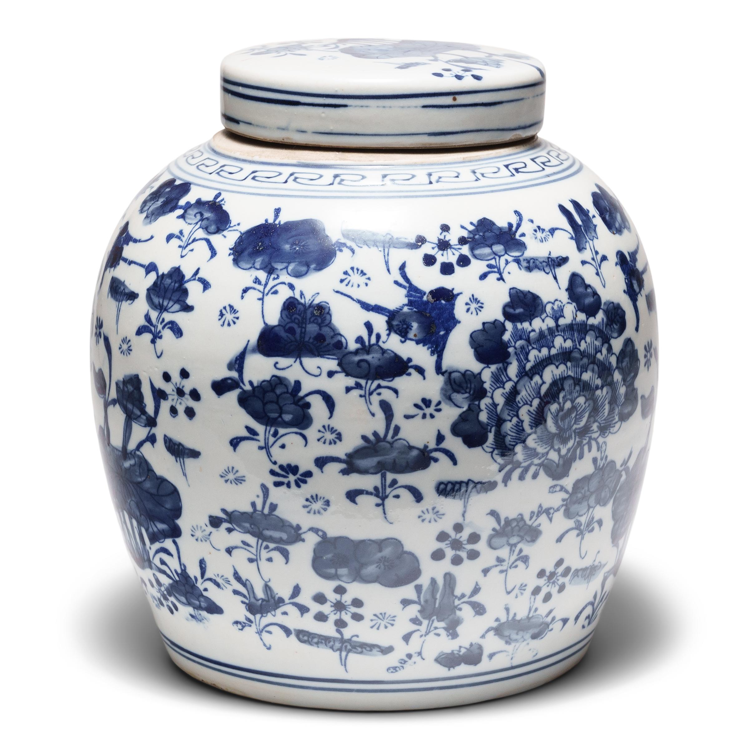 Questo vaso rotondo in porcellana è smaltato nel classico stile bianco e blu con un motivo botanico a tutto campo. Grazie alla combinazione di linee stencilate e ombreggiature spazzolate a mano, il vivace disegno è incentrato su peonie e fiori di