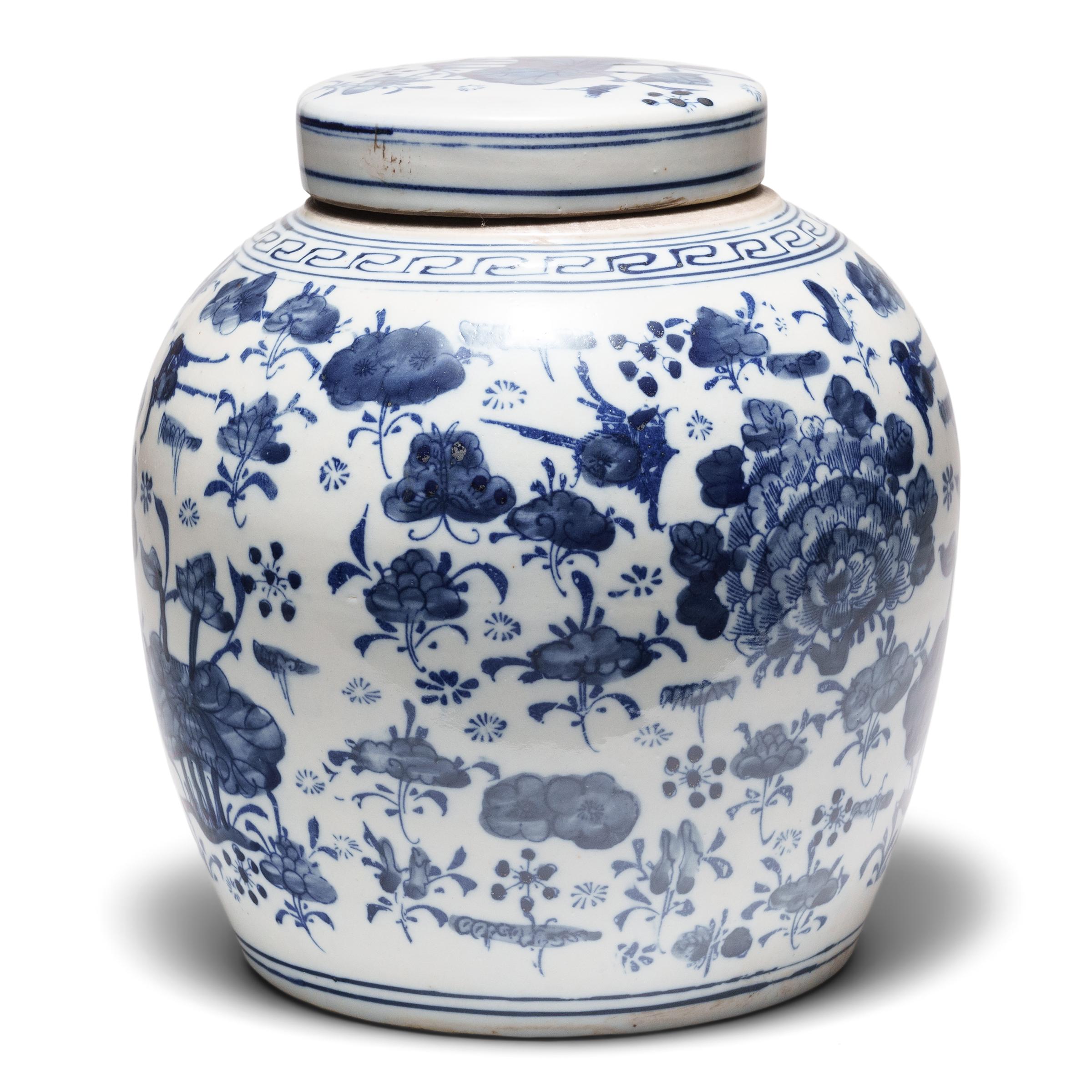 This round, porcelain storage jar is brightly glazed in the classic blue-and-white manner with an allover pattern of botanical motifs. A combination of stenciled linework and hand-brushed shading, the lively design is centered around full peonies