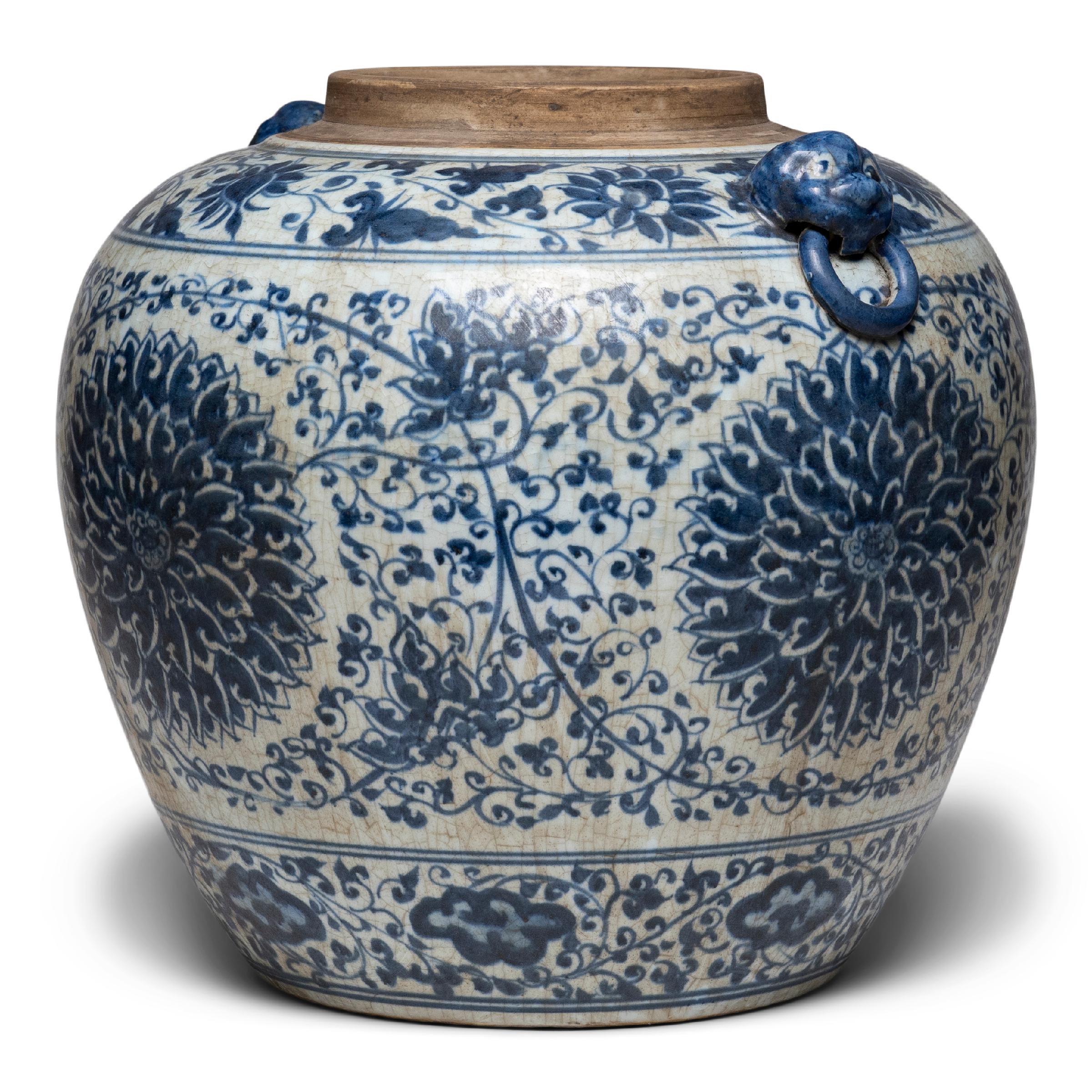 This large, tapered ginger jar continues a centuries-old tradition of Chinese blue-and-white porcelain ware. Painted with expressive brushwork, the jar is festooned with trailing vines and flower blossoms, densely patterned around large