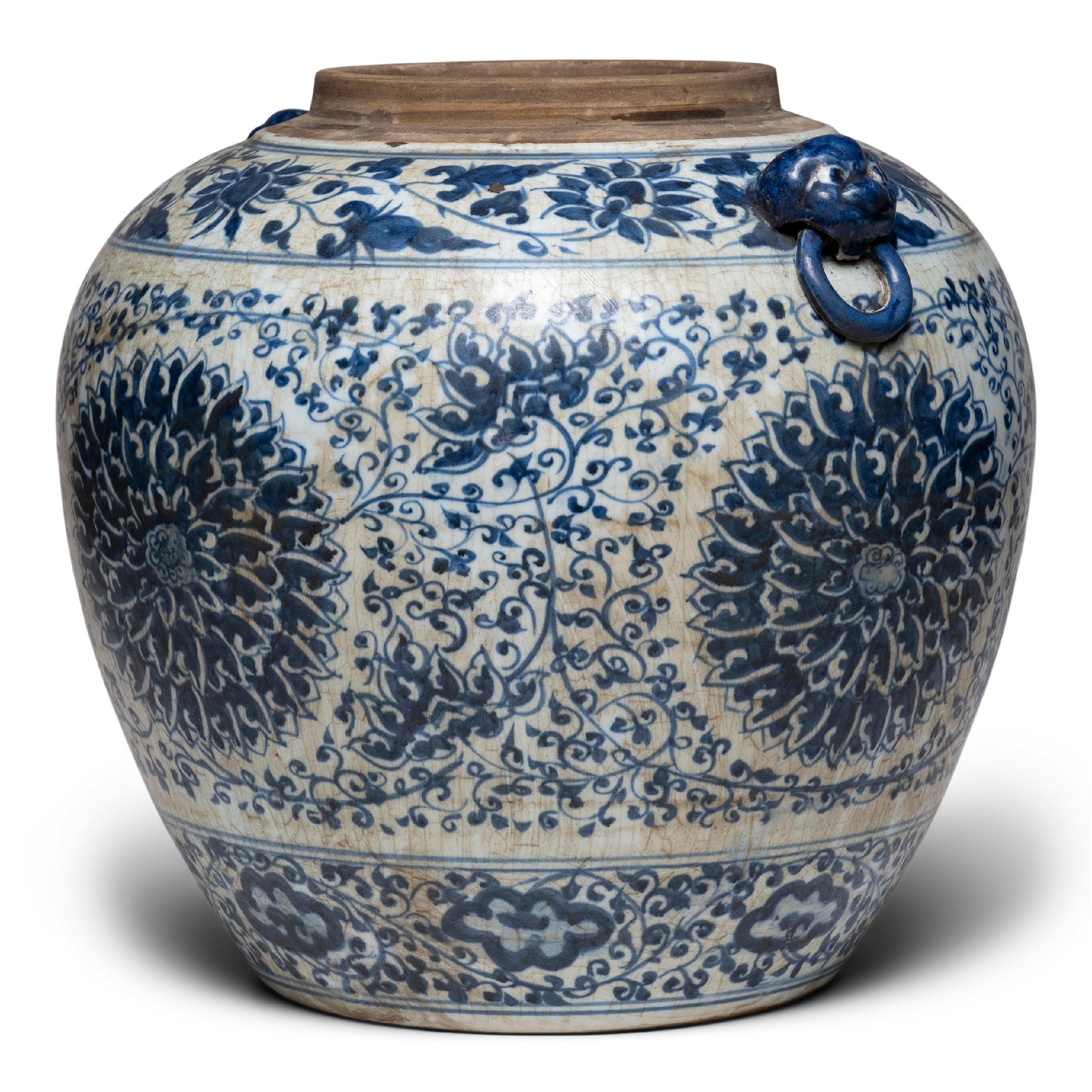 This large, tapered ginger jar continues a centuries-old tradition of Chinese blue-and-white porcelain ware. Painted with expressive brushwork, the jar is festooned with trailing vines and flower blossoms, densely patterned around large
