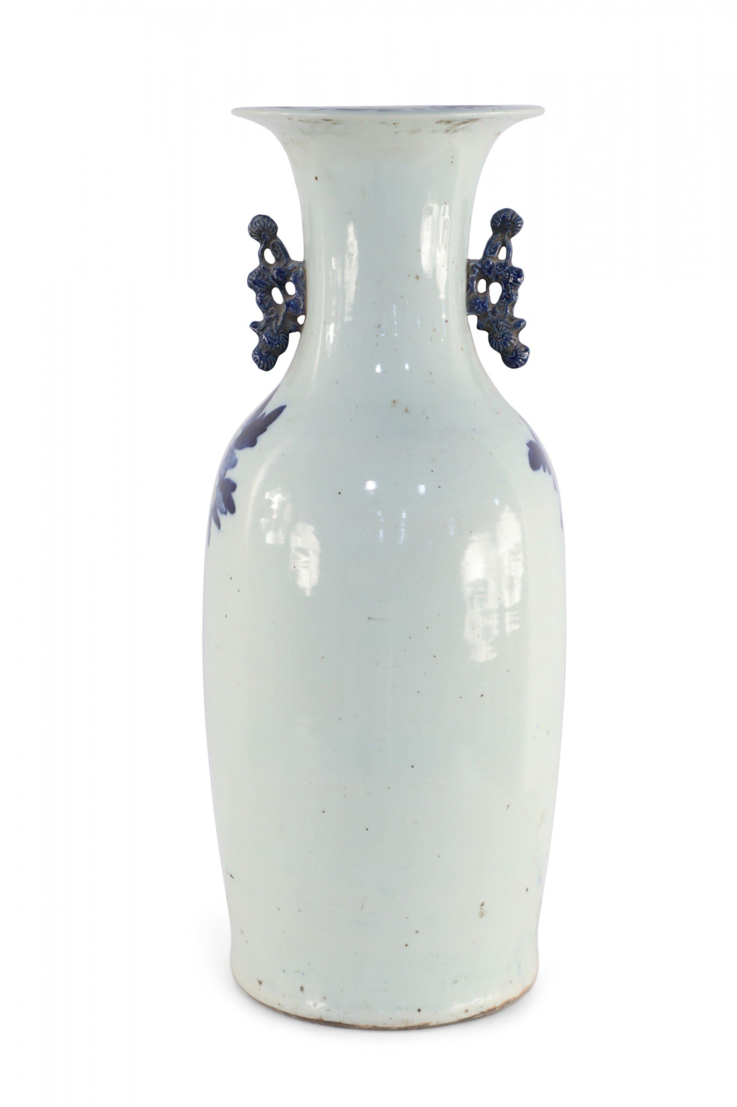 Antique Chinese (late 19th century) large porcelain urn with blue spotted deer amid florals on an off-white background and two navy scrolled handles along the neck.
      