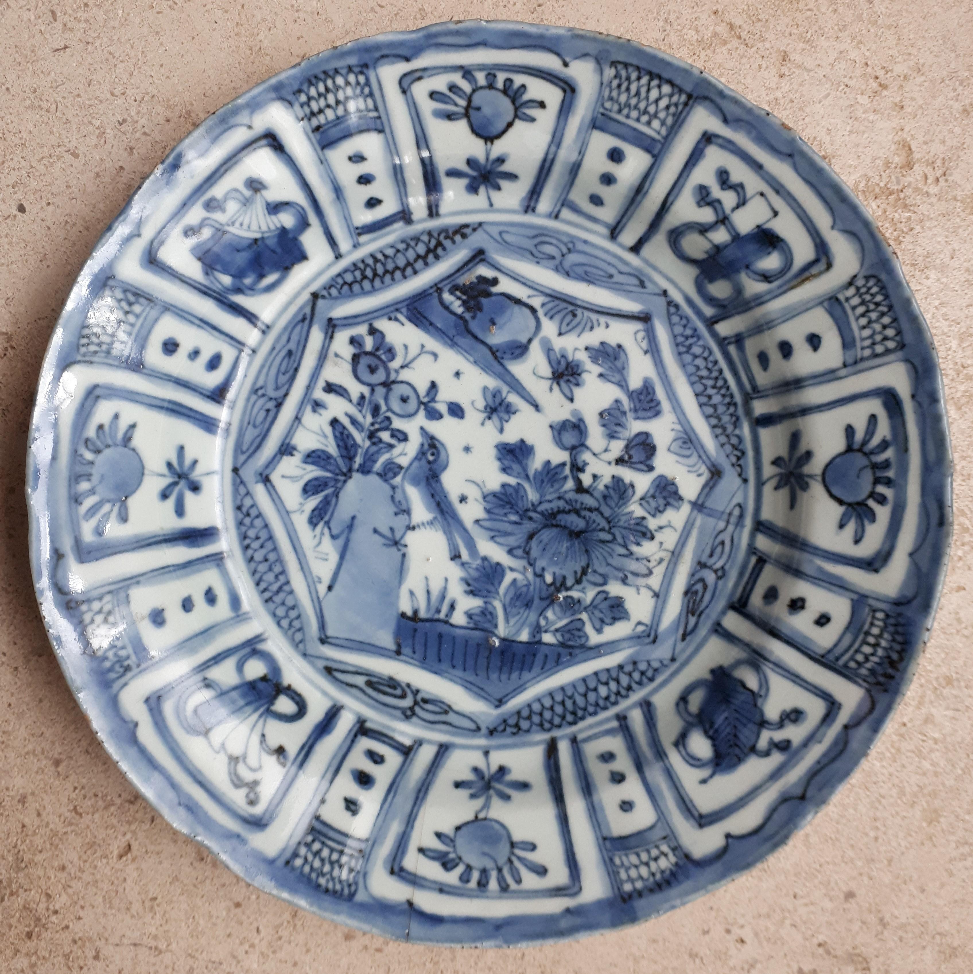 Slightly lobed dish in eight braces with flared rim with underglaze blue decoration of a bird in a garden.
Tiny chips on the edge and a slight 