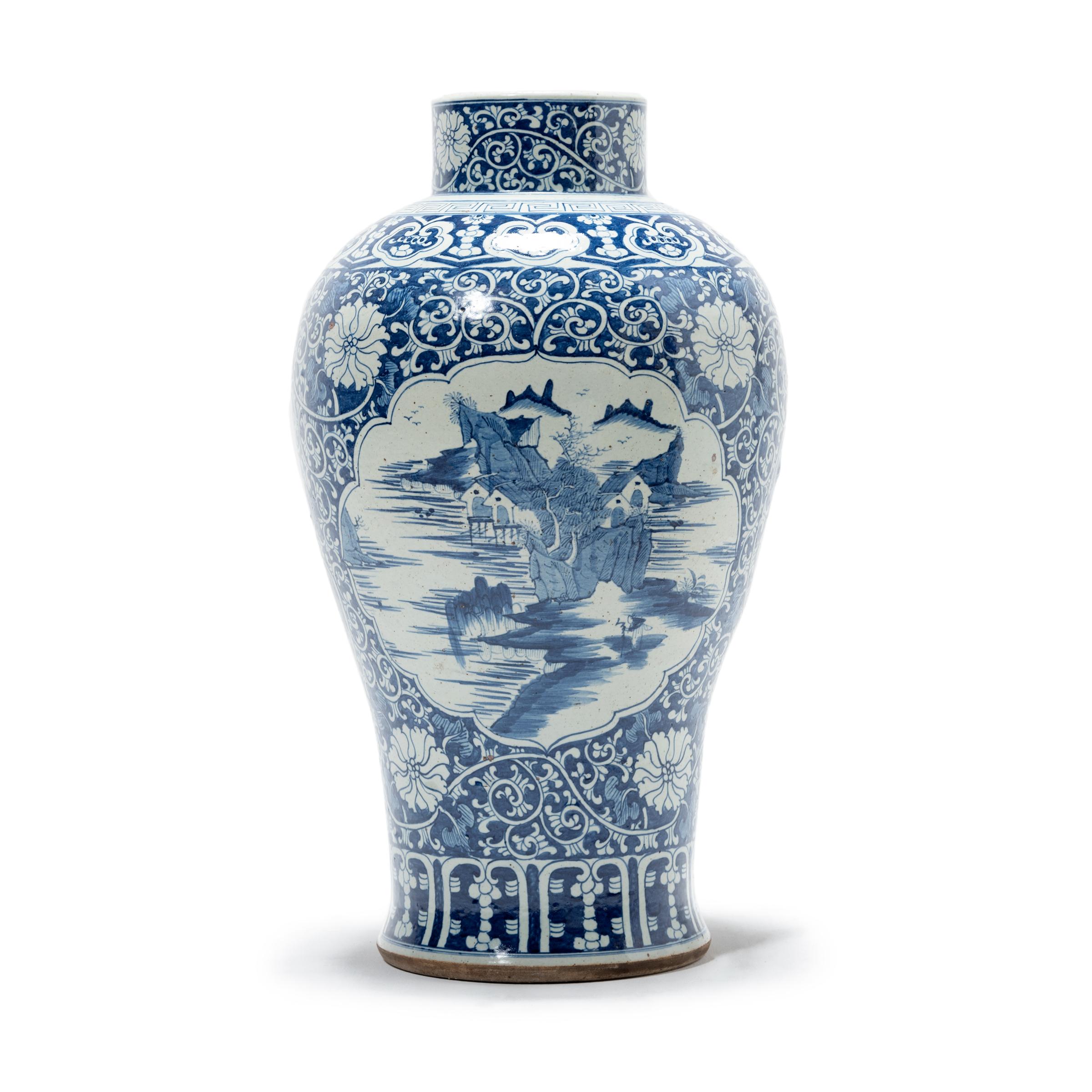 This is a monumental blue and white meiping-form vase painted by hand with a landscape scene surrounded by a floral vine motif. The cobalt oxide used to create the blue decorations was introduced to China thousands of years ago by Islamic merchants.