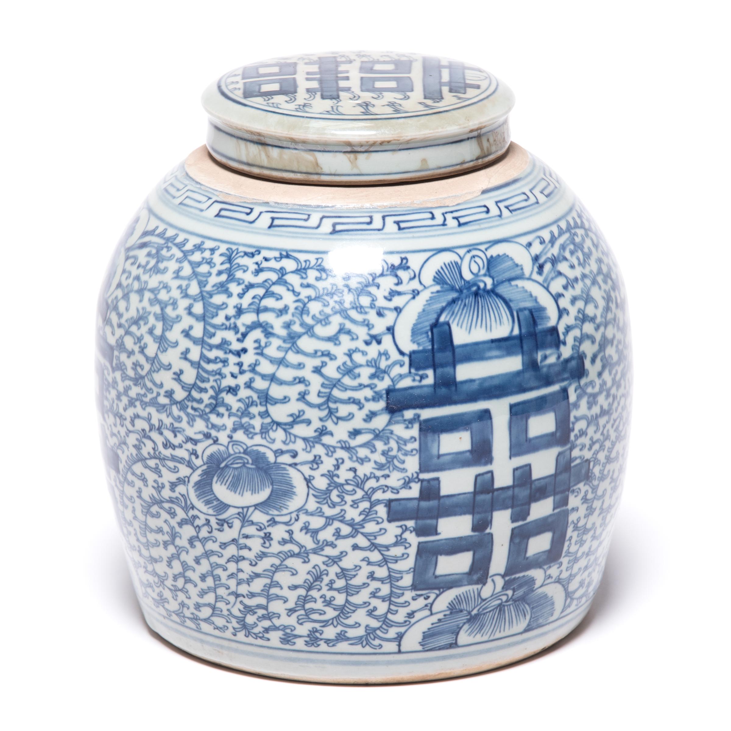 This early 20th century blue-and-white ginger jar was originally used for storing spices. Bordered by a simple Meander, the jar is densely patterned with trailing vines and orchid blossoms, symbols of love and beauty. On either side of the round jar
