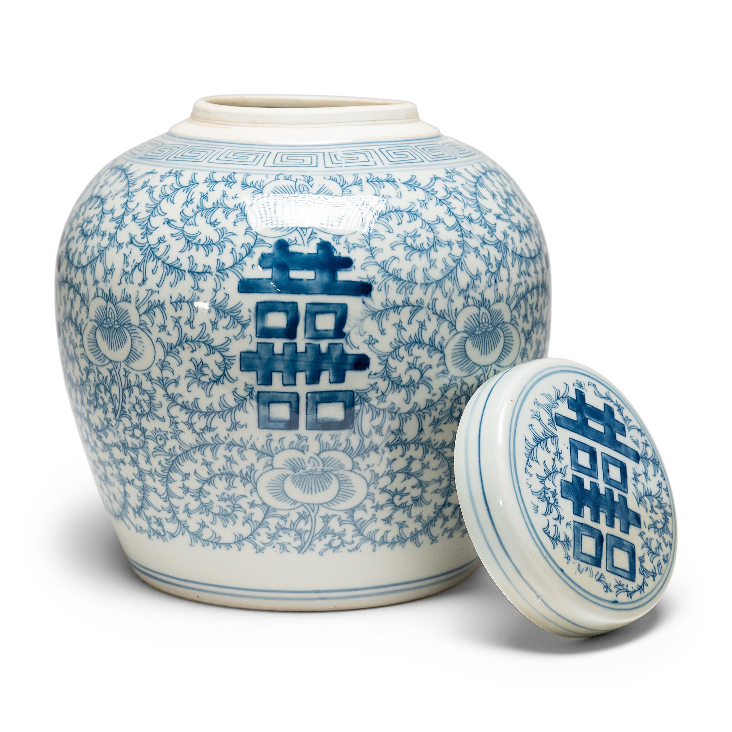 The symbol for double happiness adorns this round tea leaf jar with best wishes for love, companionship and marital bliss. Glazed in the classic blue and white manner, the porcelain jar has a rounded form with a slight taper and is topped by a flat