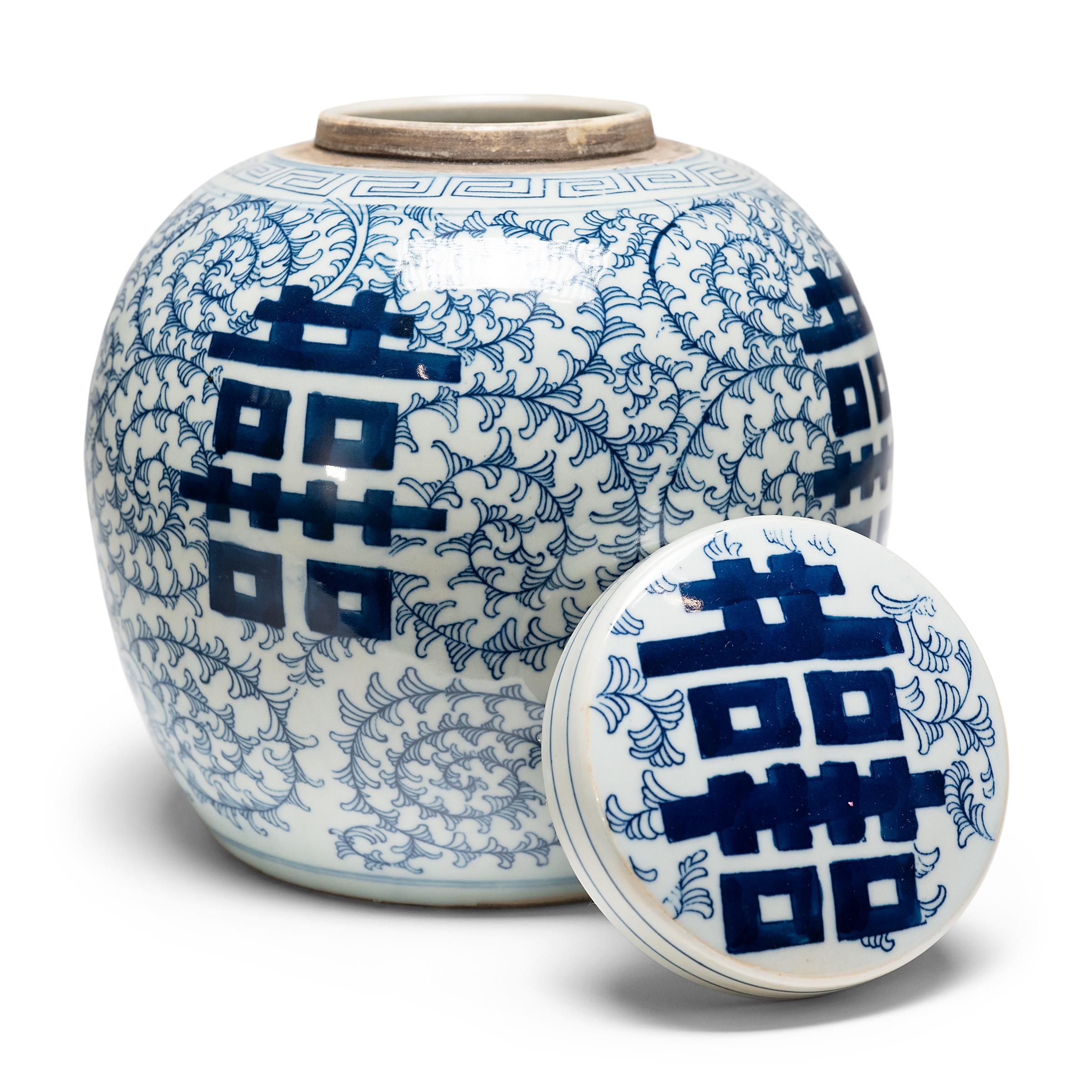 The symbol for double happiness adorns this round tea leaf jar with best wishes for love, companionship and marital bliss. Glazed in the classic blue and white manner, the porcelain jar has a rounded form and flat lid, a traditional shape for jars