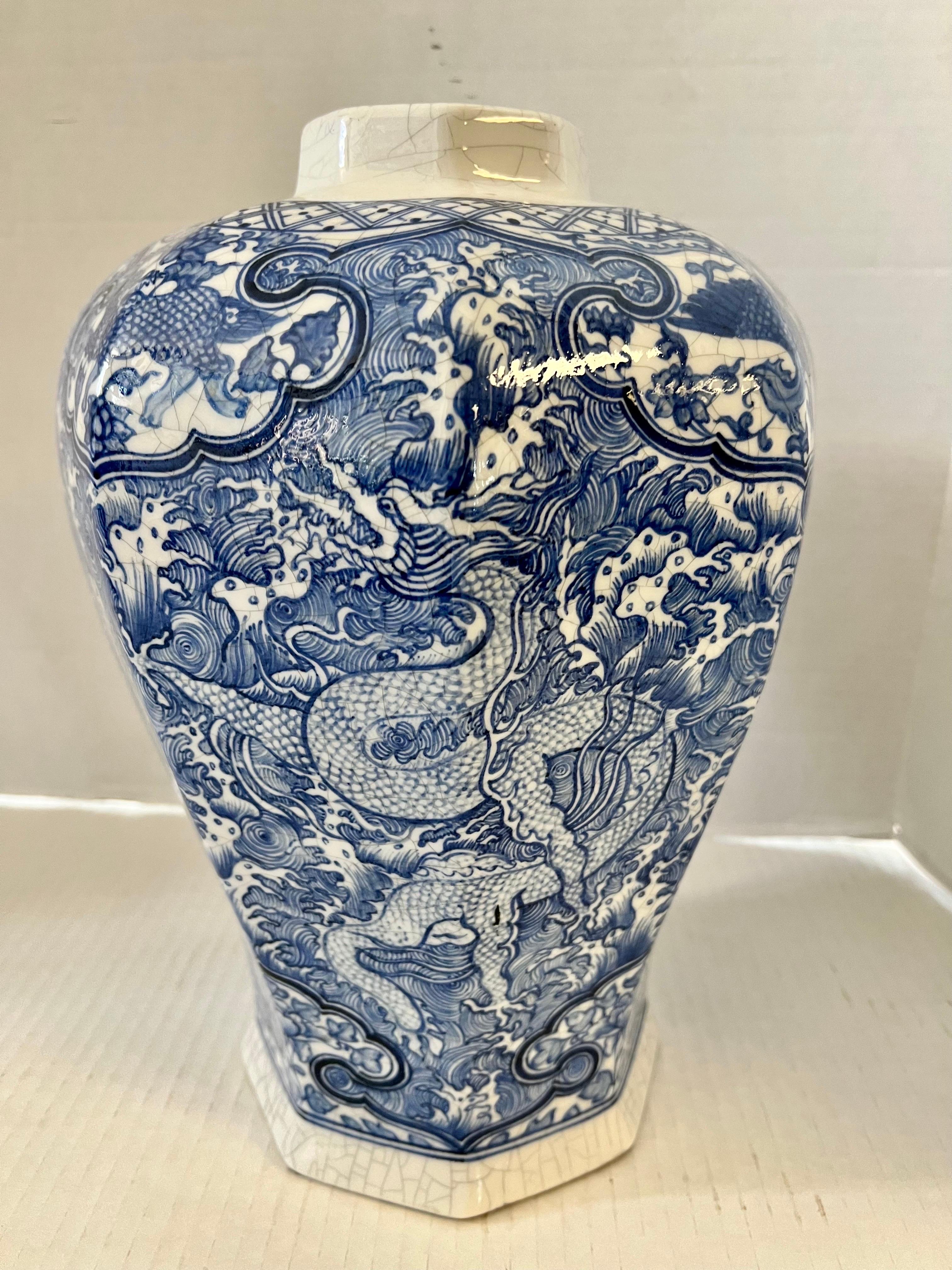 Chinoiserie glazed blue and white covered porcelain jar with intricate paintings of dragons, phoenixes, foo dogs and flowers. A foo dog stands atop the cover. Unmarked.