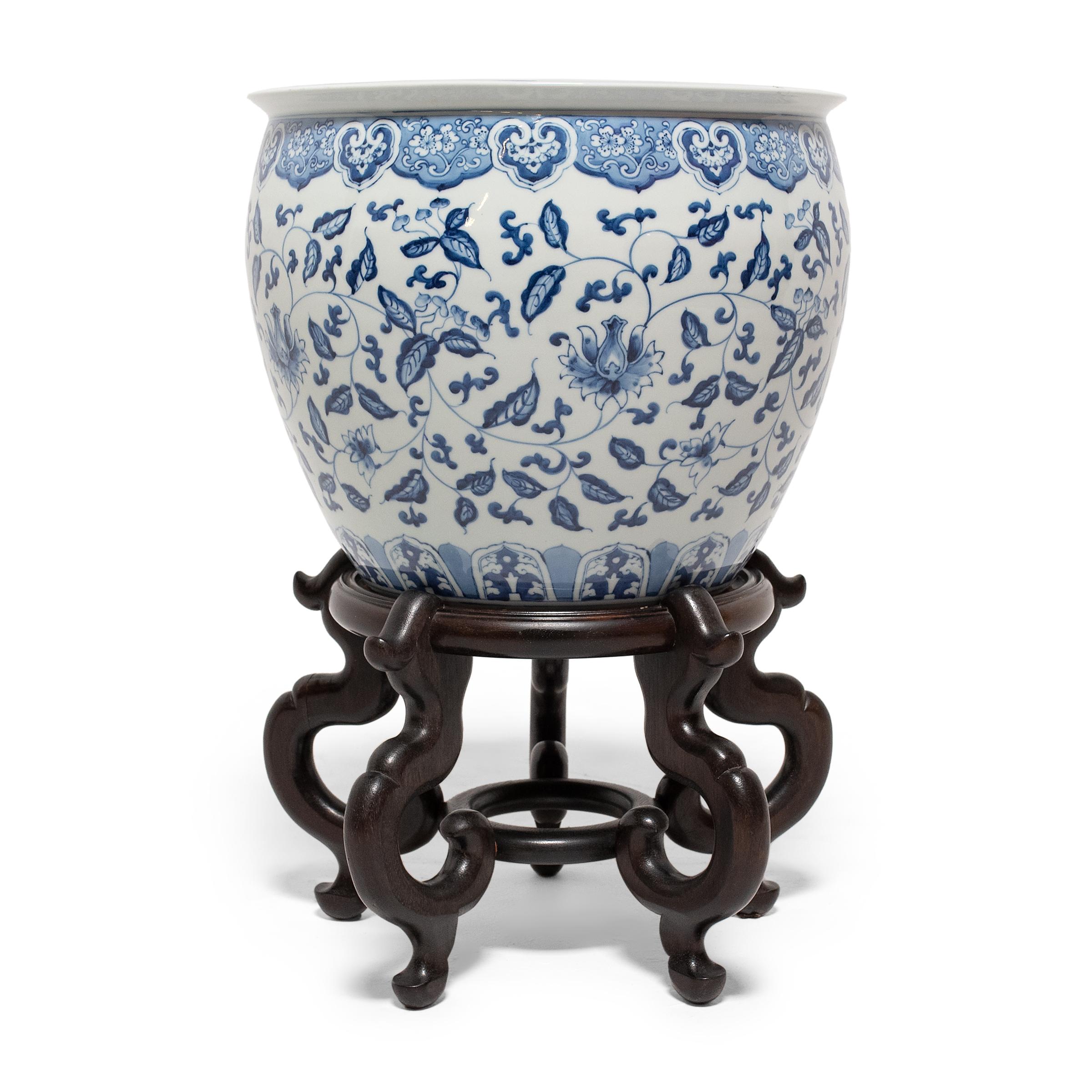 This elegant porcelain fishbowl is a lovely example of classic blue-and-white underglaze ceramics. The fishbowl is decorated with an all-over pattern of scrolled vines and flowers, framed by ruyi-form floral medallions at the lip and a band of