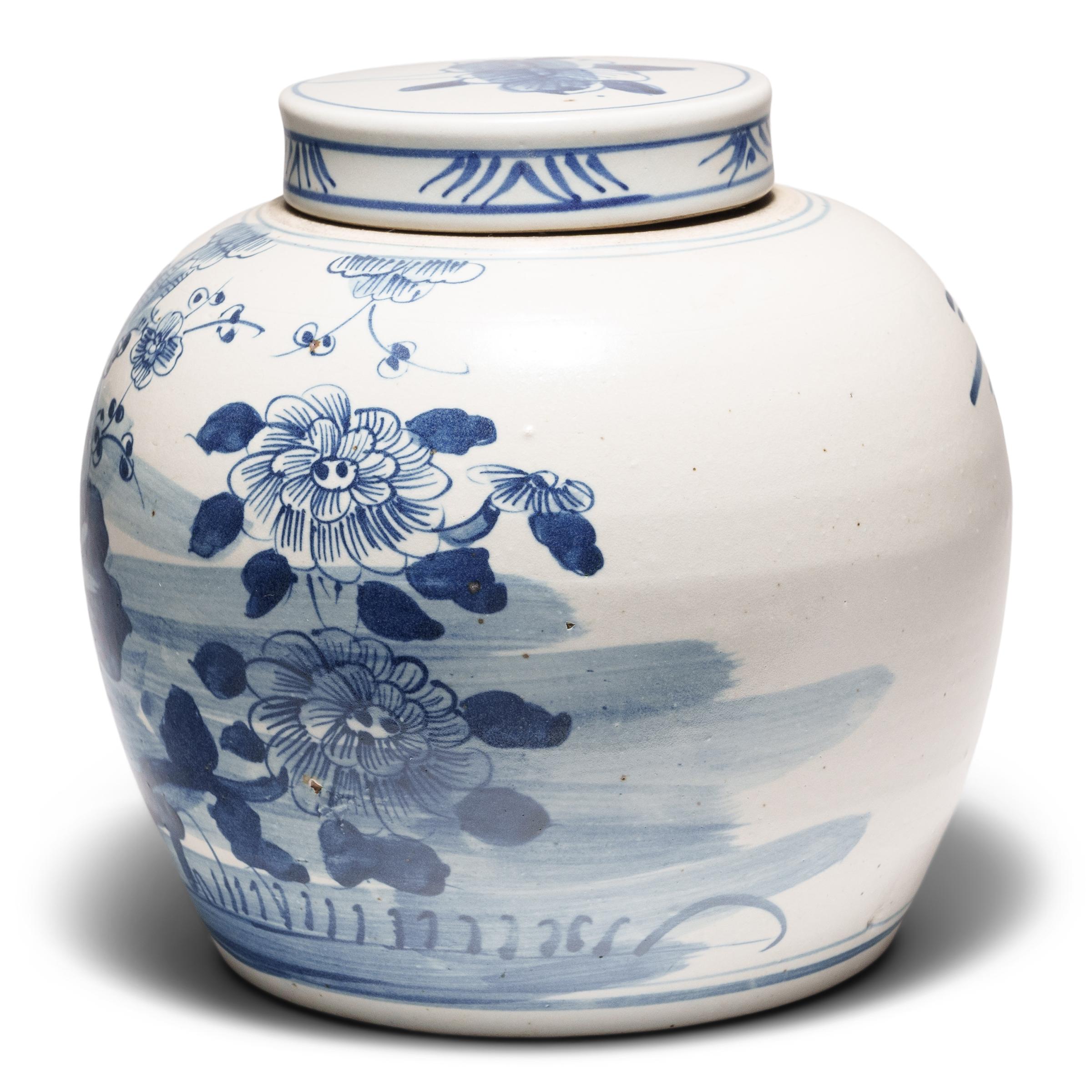 Loosely brushed with cobalt blue pigments, this round, blue-and-white storage jar is underglazed with lush garden scenery featuring the flowering plants of the four seasons. Tree peonies for spring adorn the left side, while round chrysanthemum