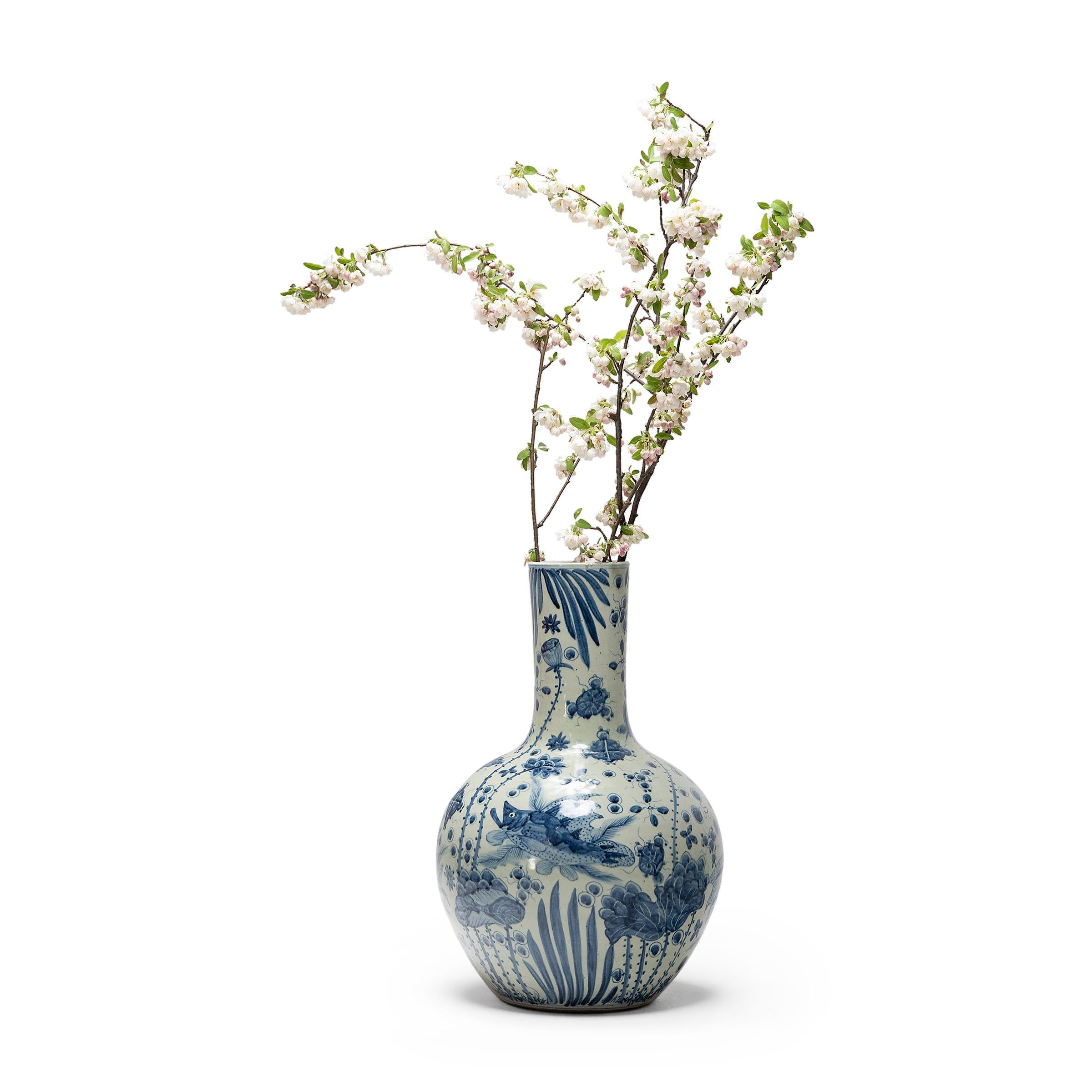 Elaborately finned fish make their way in a vibrant underwater world on this tall blue-and-white gooseneck vase. Patterned with real and abstract forms, this ceramic vase is a contemporary take on traditional Chinese blue-and-white porcelain. The