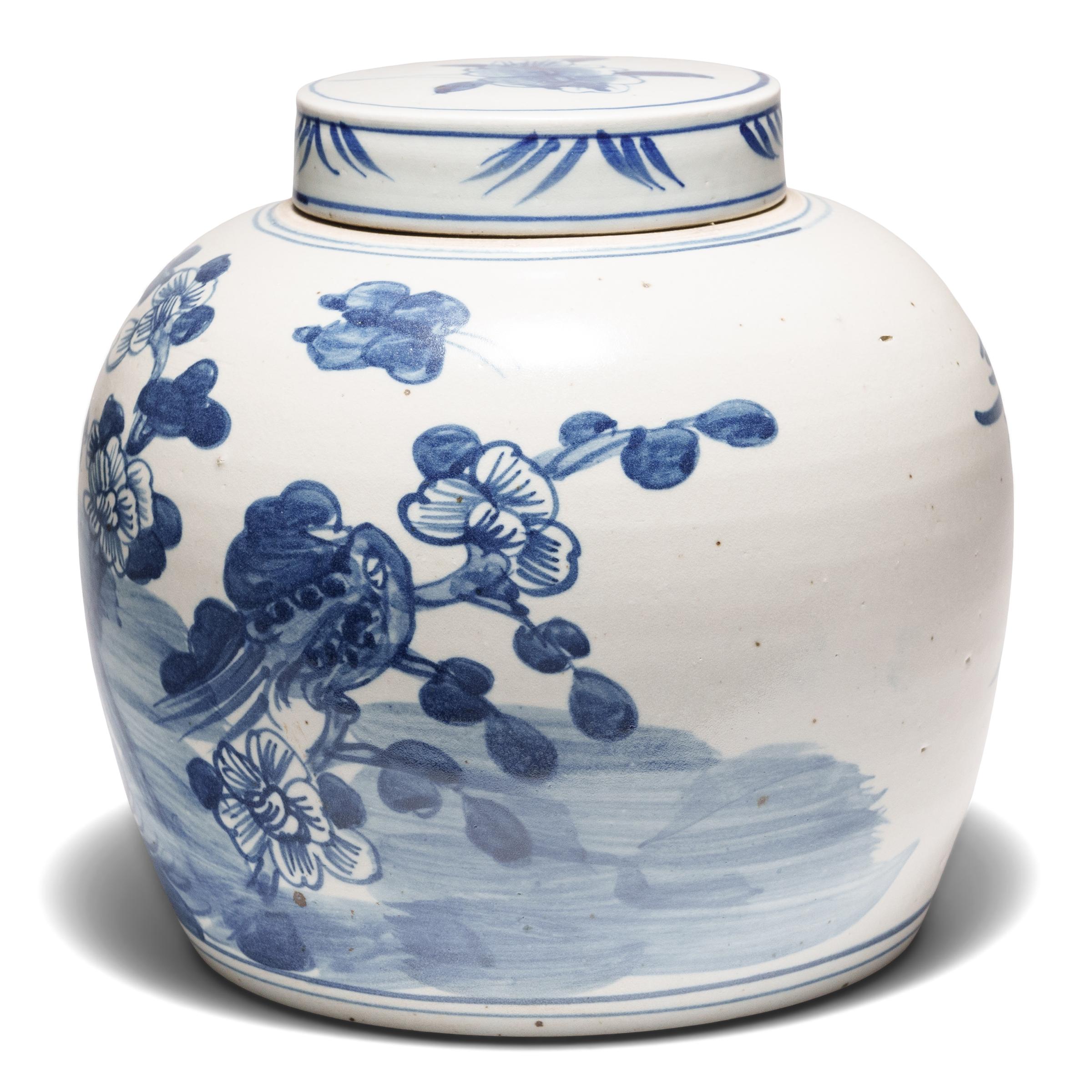 Loosely brushed with cobalt blue pigments, this round blue-and-white storage jar is adorned with a ribbon-tailed bird perched on a cluster of rocks, a symbol for a long and happy life. In combination with the surrounding peony blossoms, emblems of