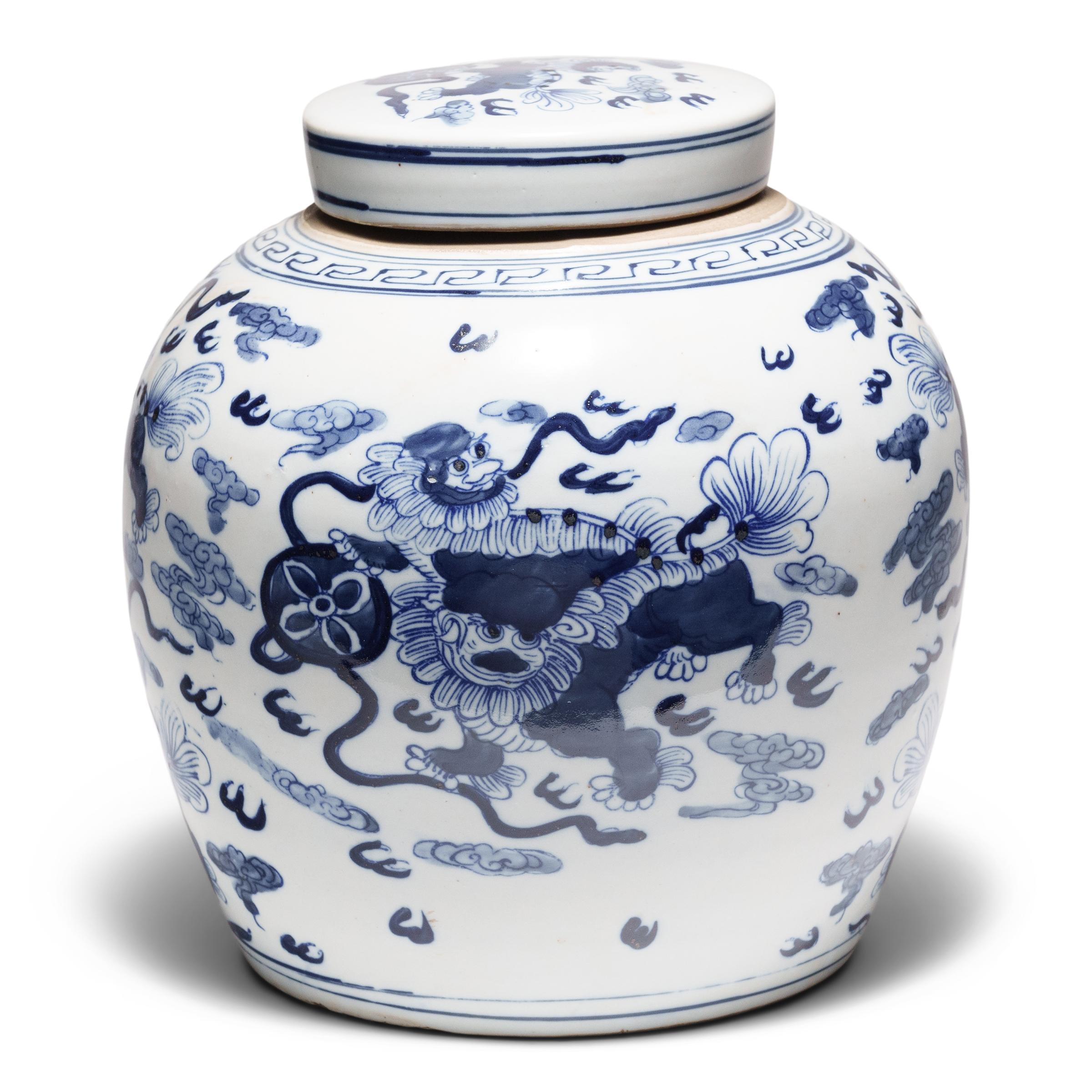 Questo barattolo rotondo in porcellana è smaltato in modo brillante nel classico stile bianco e blu. Grazie a una combinazione di linee stencilate e ombreggiature spazzolate a mano, i lati del vaso sono decorati con due mitici cuccioli di leone fu