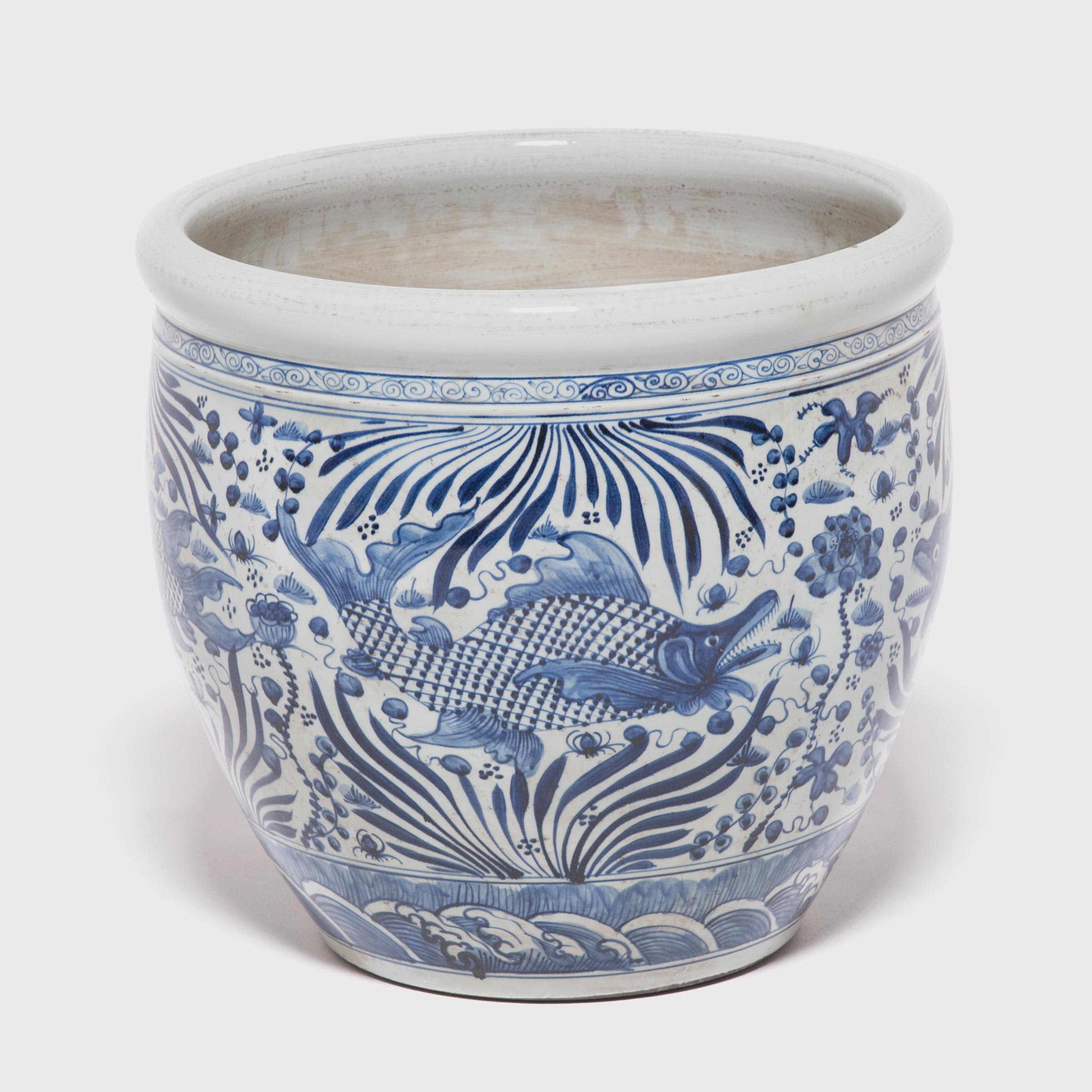 This grand, blue-and-white porcelain bowl is hand-painted with flora and fauna of the sea, offering blessings of wealth, abundance, and the contented harmony of a fish in water. Chinese blue-and-white ceramics have inspired ceramists worldwide since