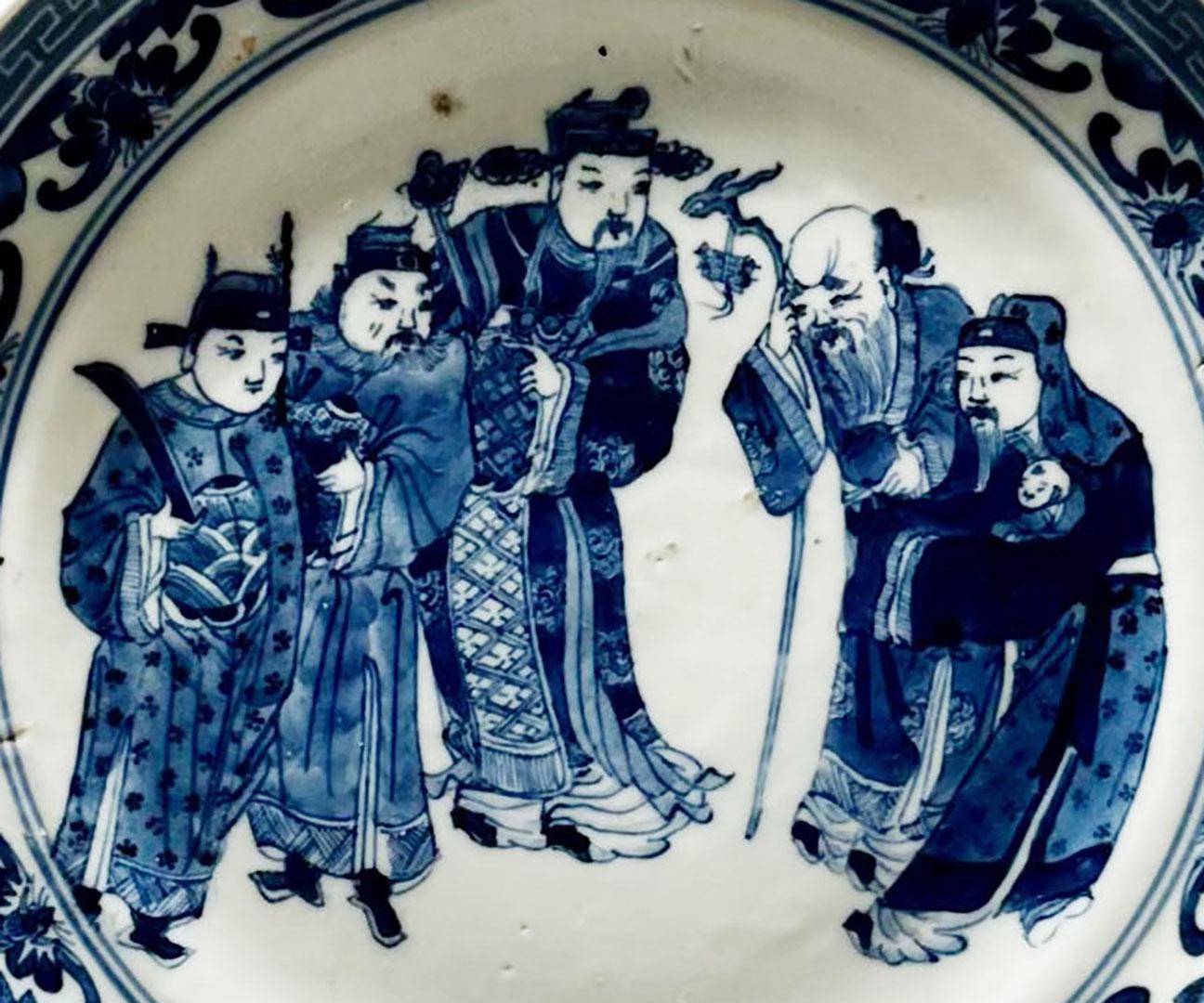 Assiette chinoise en bleu et blanc du début du XIXe siècle représentant cinq hommes nobles et une magnifique bordure de chauves-souris et de clés grecques.