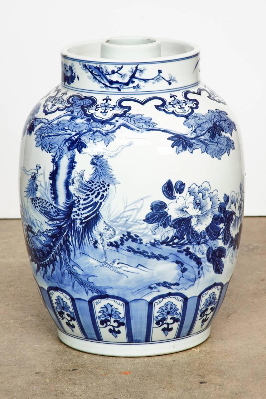 Monumental Chinese blue and white porcelain jardinière or planter. Decorated in the Kangxi style with large exotic birds and a floral motif of small window designs on the bottom. The thick neck is 10