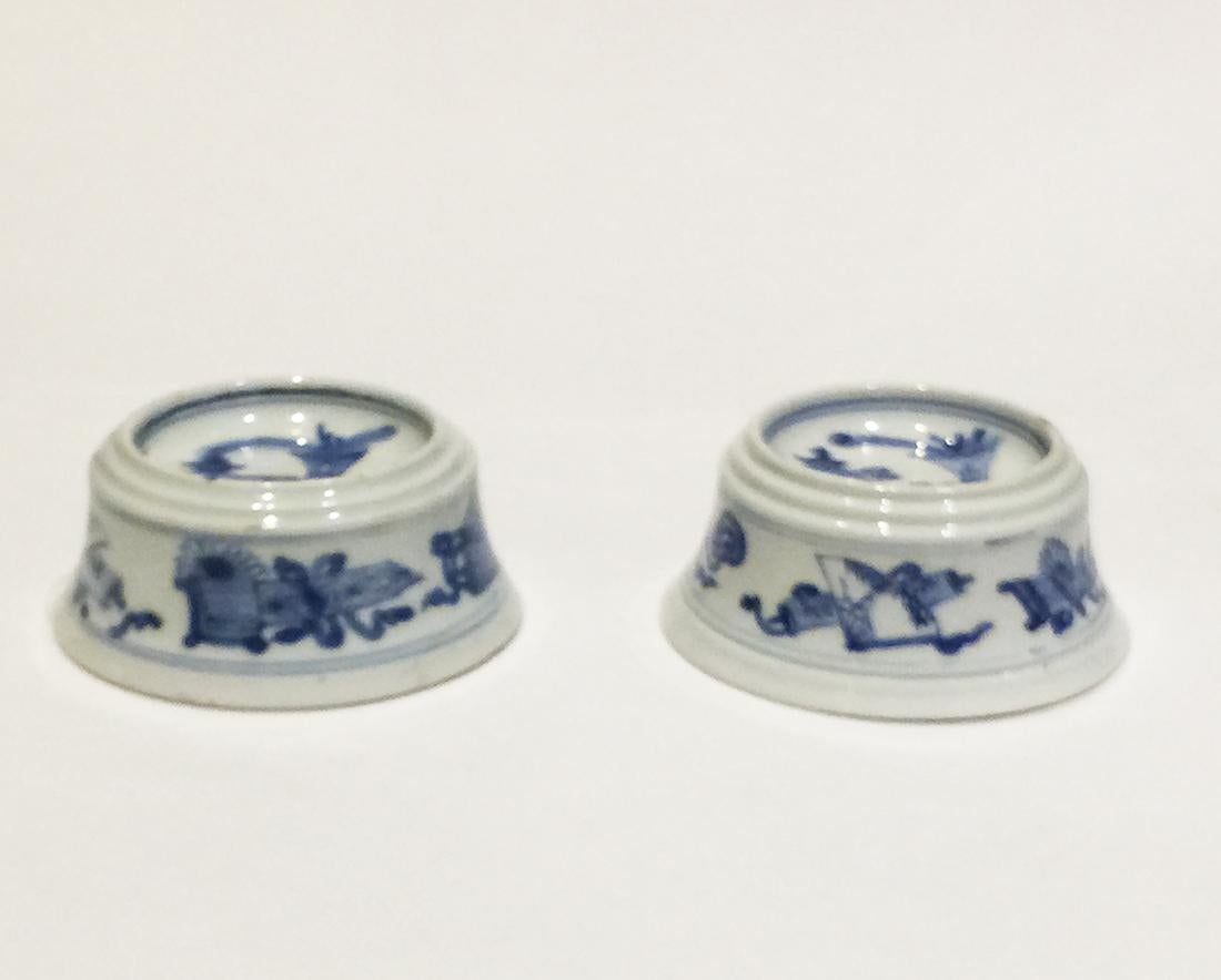 Chinese porcelain salt cellars, Kangxi (1662-1722)

2 Chinese porcelain salt cellars with 3 rims and inside the double blue ring a scene of several symbols
Vase with peacock feathers, insence burner and a book
On the side also a scene of several