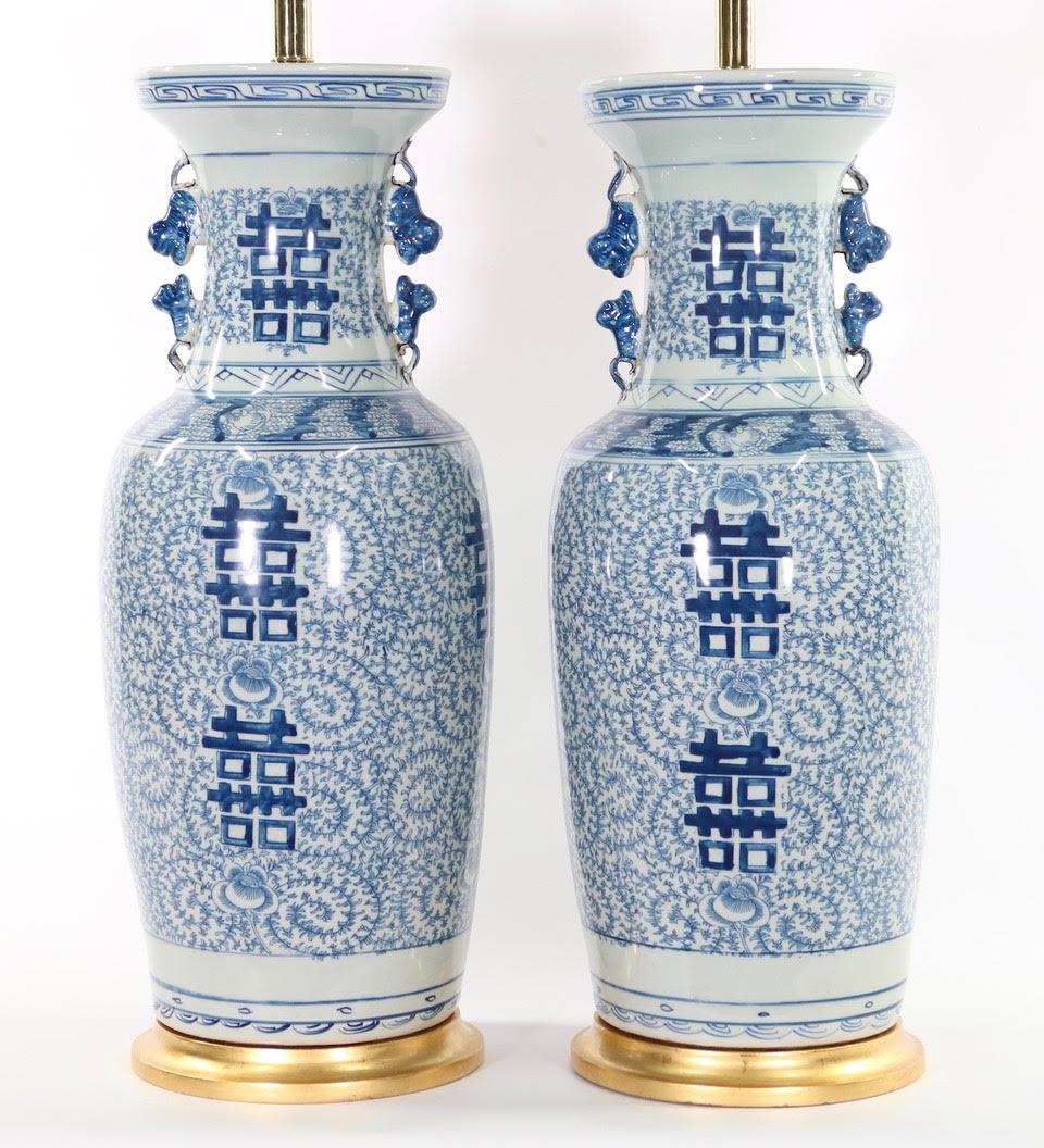 Pair of large Chinese blue and white porcelain vases mounted as table lamps, with double happiness symbols, dating from the early 20th century and mounted on gilt wooden bases.
The height to the top of the ceramic body is 25.25 inches.
The pair is