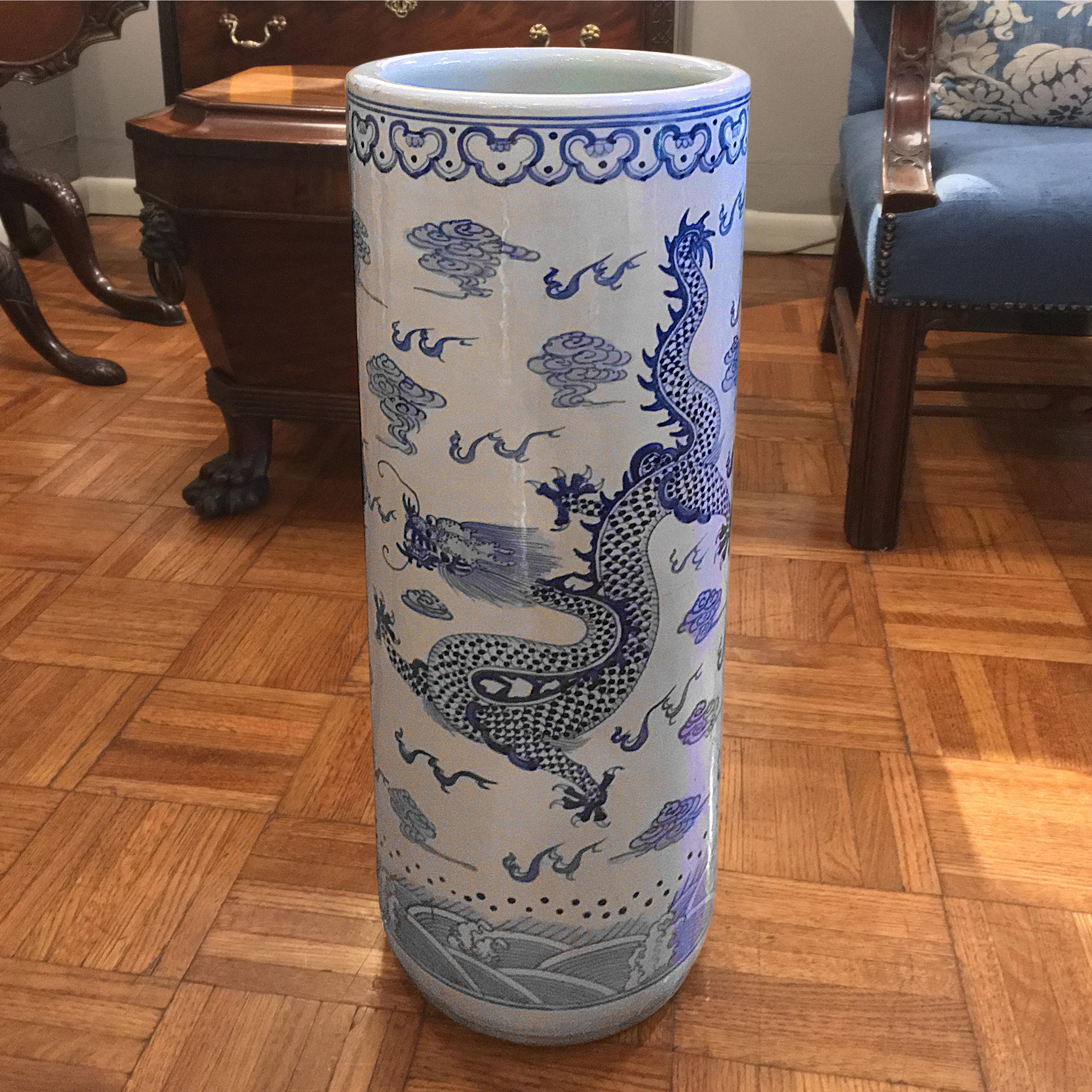 This cylindrical Chinese porcelain vase would make a perfect umbrella stand. Decorated in cobalt blue with a dragon, clouds, and rolling hills.
 