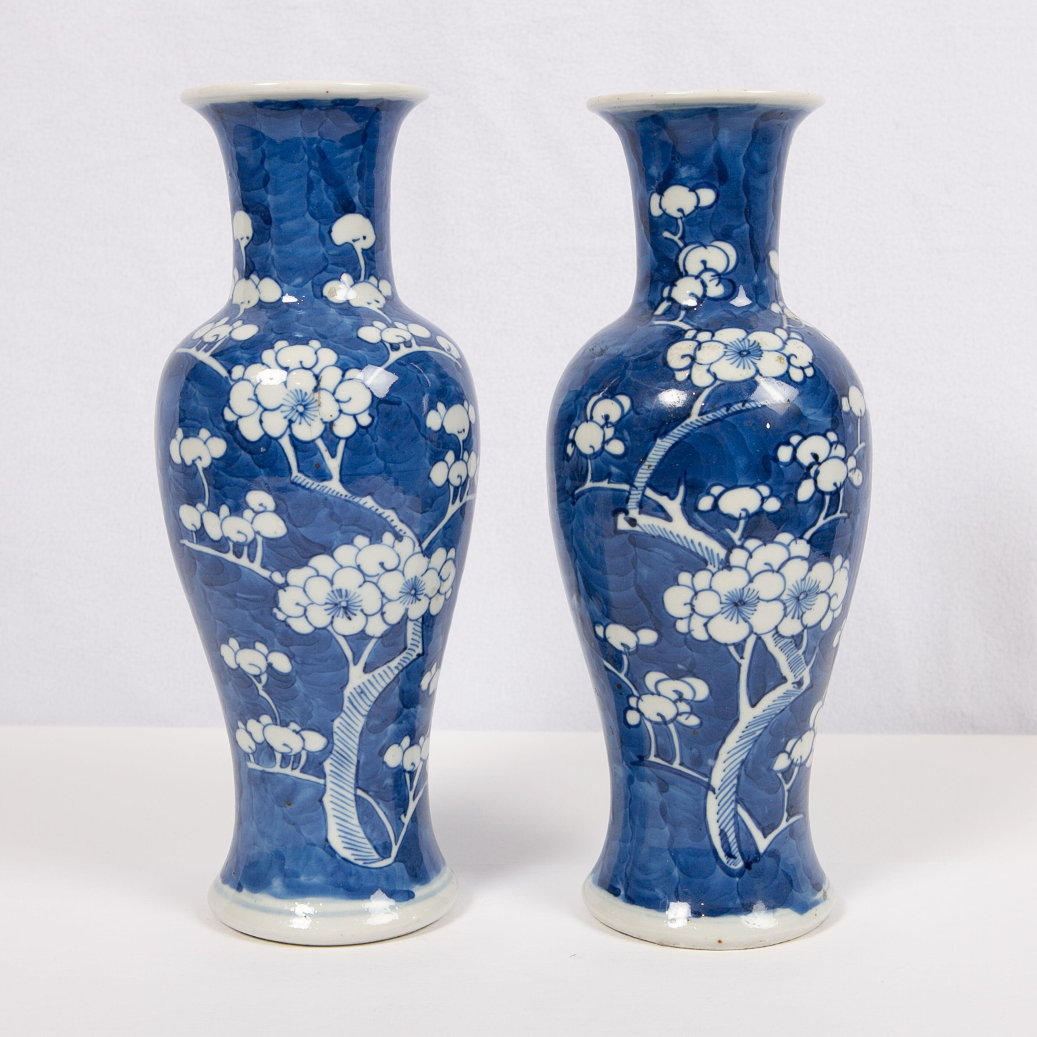 We are pleased to offer this pair of antique Chinese blue and white porcelain vases made in the late Qing period of the 19th century, circa 1880. They are decorated with white plum blossoms. The white blossoms are set on a blue ground with subtle