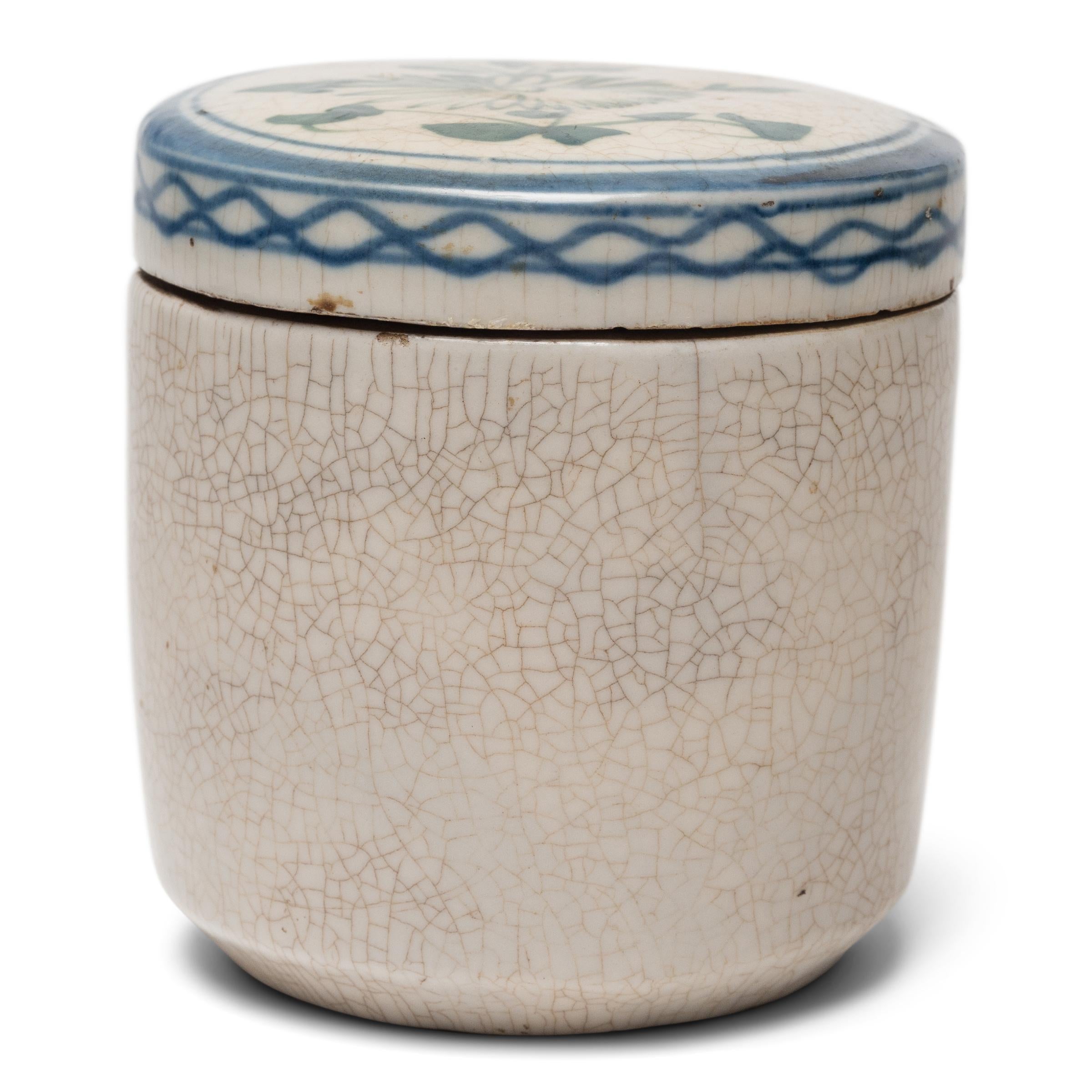 Used to store loose leaf tea, this small earthenware jar from the late 19th century is decorated in the classic blue-and-white manner with a richly crazed texture. Elegant in its simplicity, the humble jar is decorated only on the lid, loosely
