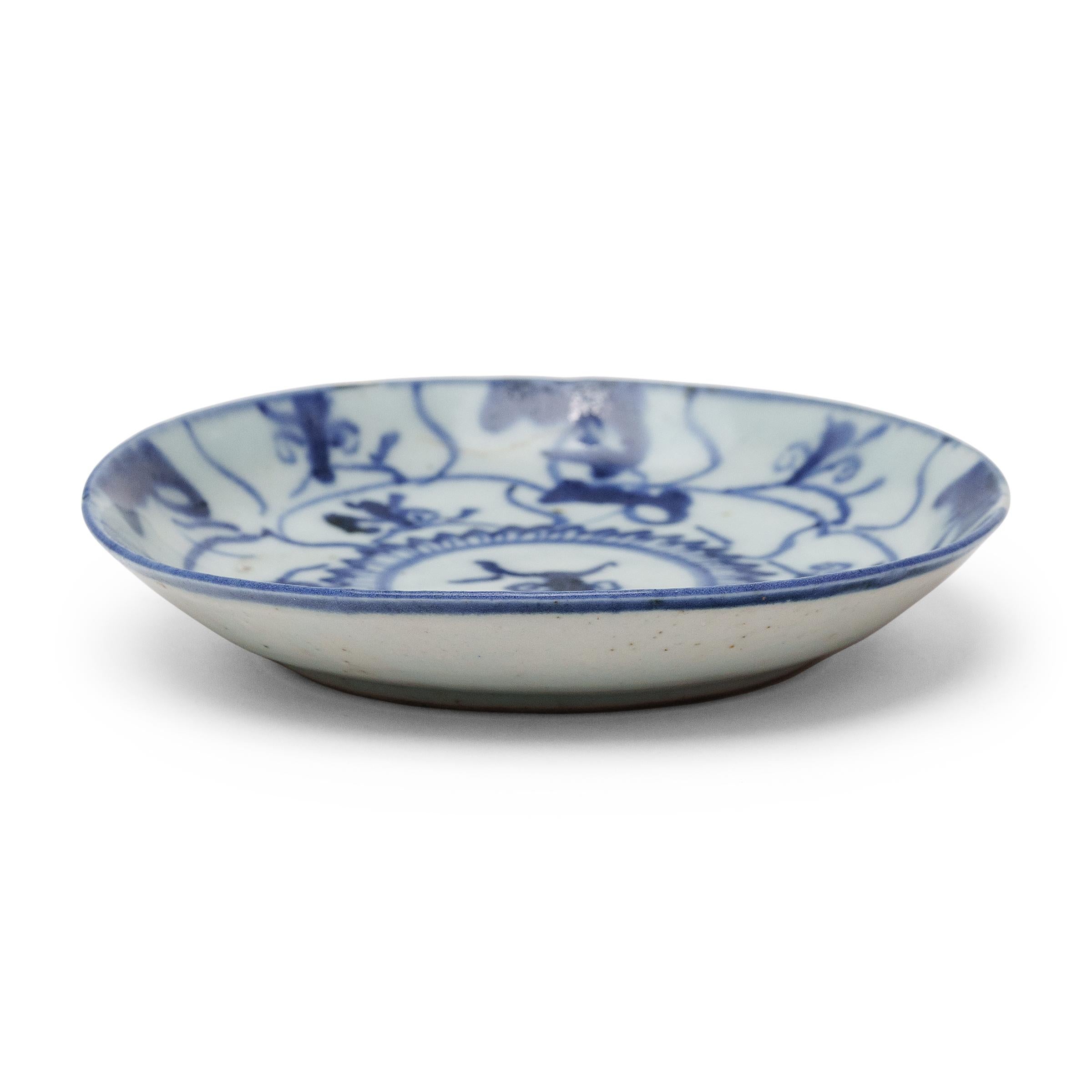 An everyday example of Chinese blue-and-white porcelain, this 19th-century porcelain plate charms with expressive cobalt-blue decoration, sparsely brushed with deep pigmentation against a blue-grey field. Shaped with gently curved sides, the plate