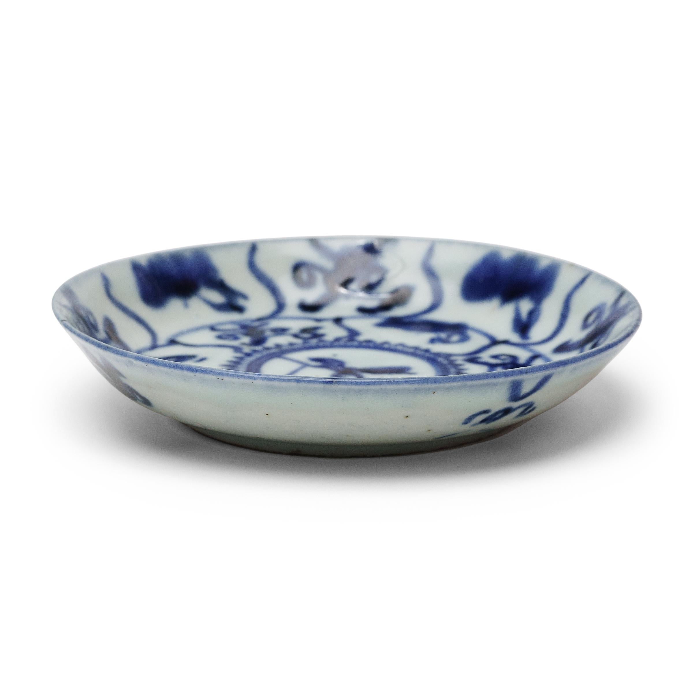 An everyday example of Chinese blue-and-white porcelain, this 19th-century porcelain plate charms with expressive cobalt-blue decoration, sparsely brushed against a blue-grey field. Shaped with gently curved sides, the round plate is decorated with