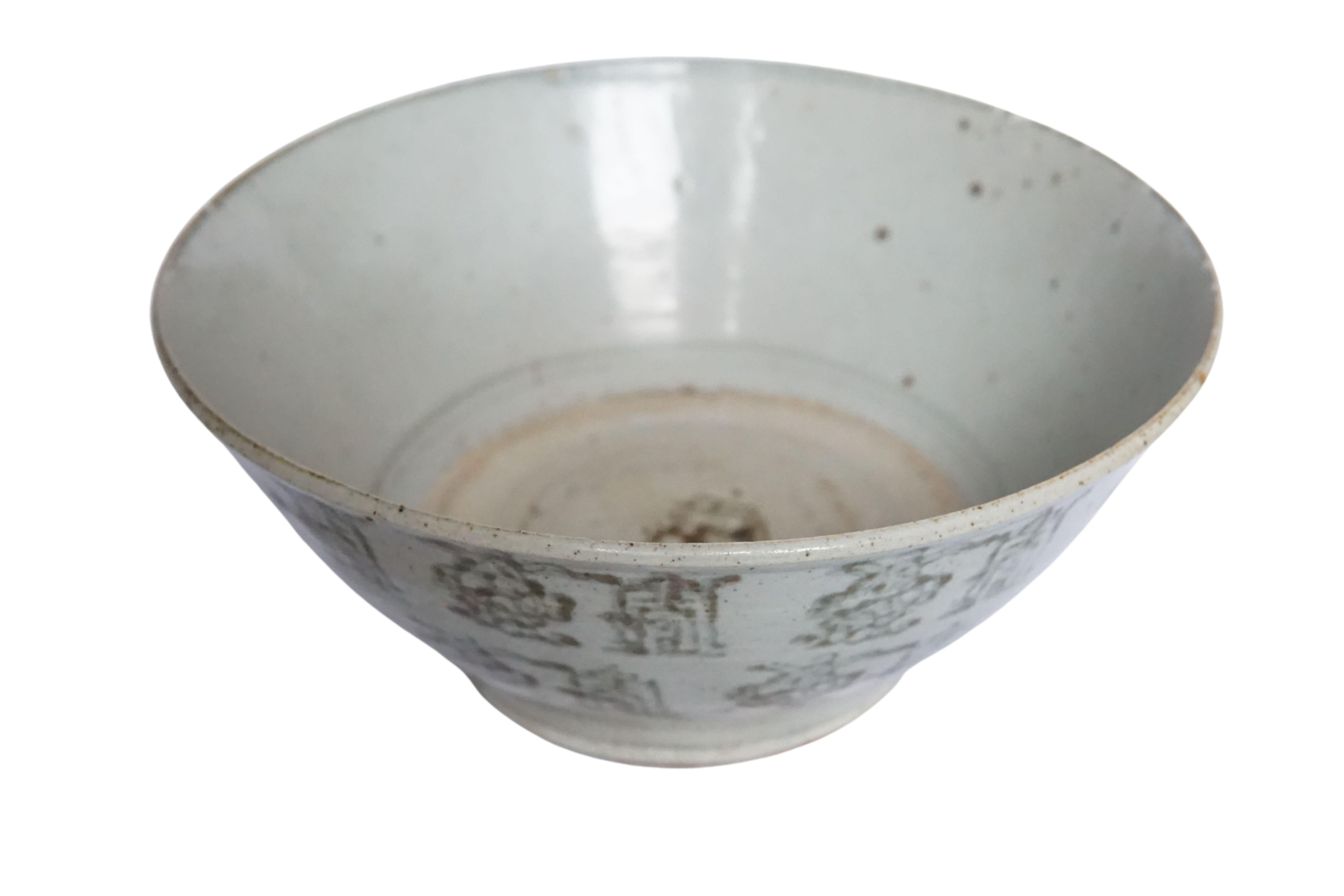Diese chinesische Keramikschale aus der Qing-Dynastie wird von einer blau-grauen Glasur dominiert und weist wunderschöne handgemalte Symbole auf. Einst als alltägliche Schale verwendet, ist sie heute ein großartiges Beispiel für chinesische Keramik