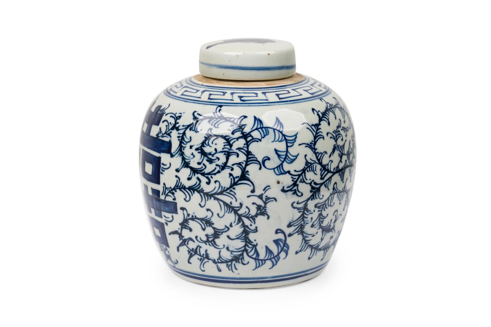 Jarra ovoide de porcelana china azul y blanca con caracteres caligráficos en la tapa más un borde doble, el cuerpo pintado con un borde de greca que rodea la boca, un motivo foliado debajo con 2 lados opuestos que muestran una versión ampliada de la