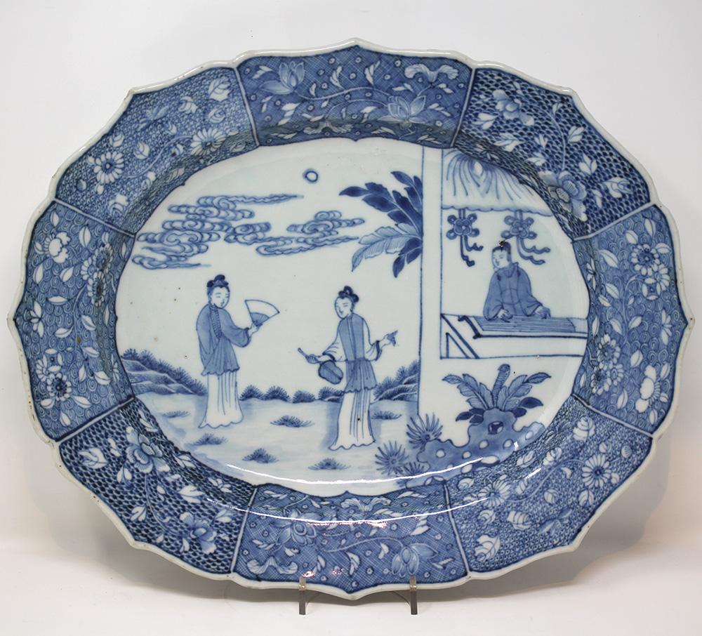 Chinese blue and white oval export platter featuring a scene from the romance of the western chamber. The plate with pinched edge and boldly decorated boarder intricately decorated with floral scenes. The central scene beautifully painted with two