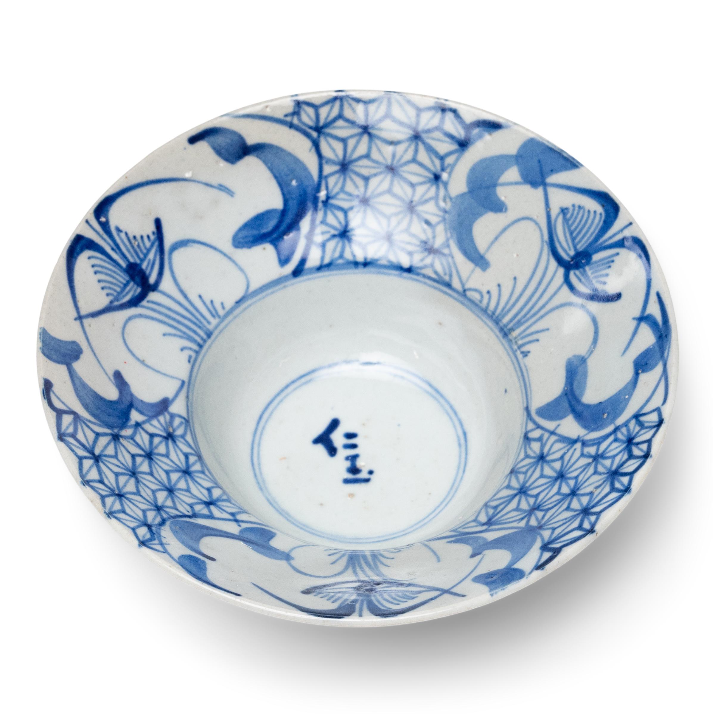 Diese Porzellanschale mit Fuß stammt aus dem frühen 20. Jahrhundert und ist mit ausdrucksstarken Pinselstrichen im blau-weißen Stil handbemalt. Die kleine Schale hat eine dramatische, ausladende Form mit einem schmalen Becken und einer schrägen