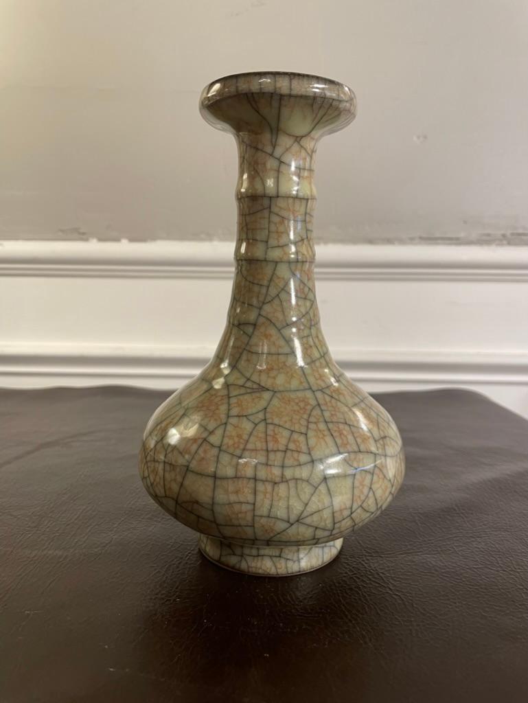 A Chinese crackle glazed bottle form ceramic vase of lovely form and proportions. The celadon colored glaze crazed with a glaze of cinnamon red crackles bordered by larger black crackles, just beautiful. Elegant bottle form, with ribbed neck and