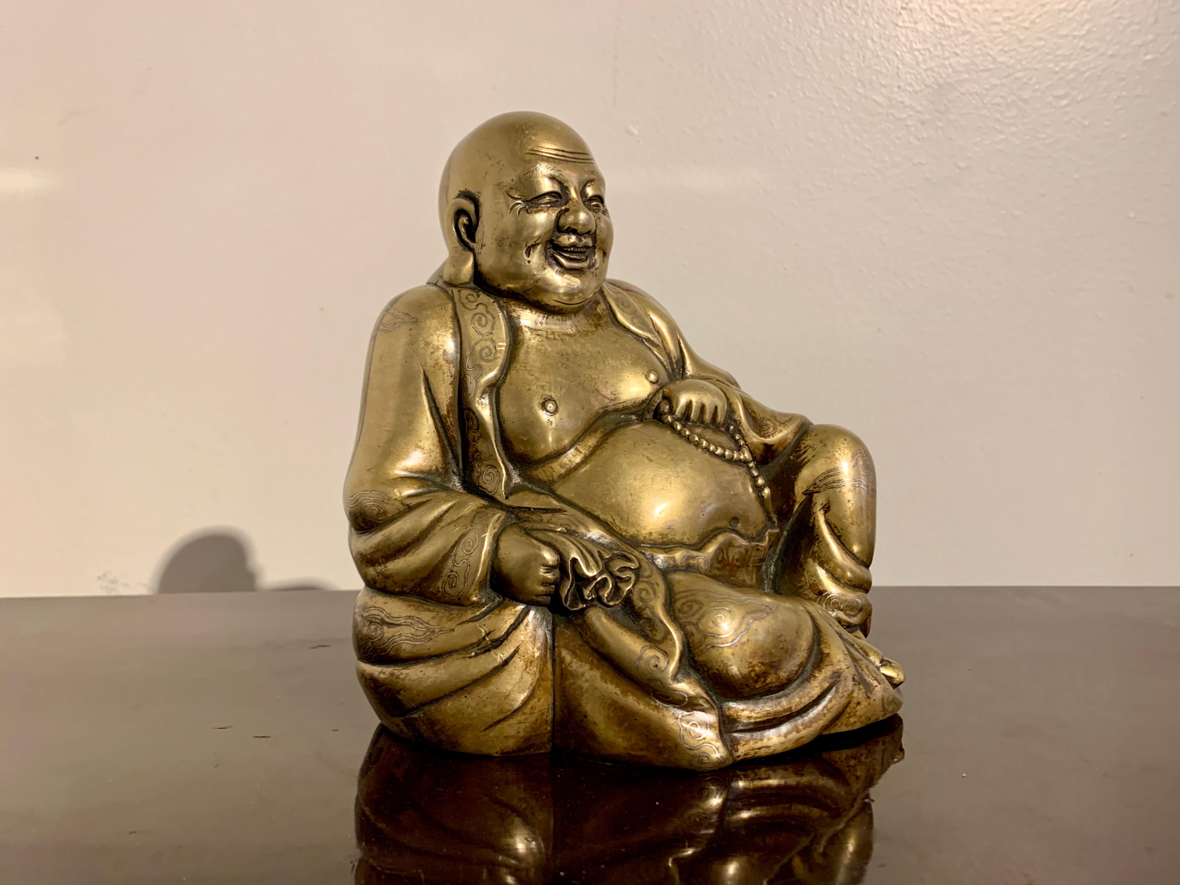 A delightful heavily cast Chinese brass and silver inlaid figure of Budai, the Laughing Buddha, inlaid Shishou mark, Qing Dynasty, 19th century or earlier, China.

Budai, often referred to as the Happy Buddha, Laughing Buddha, or Fat Buddha, is a