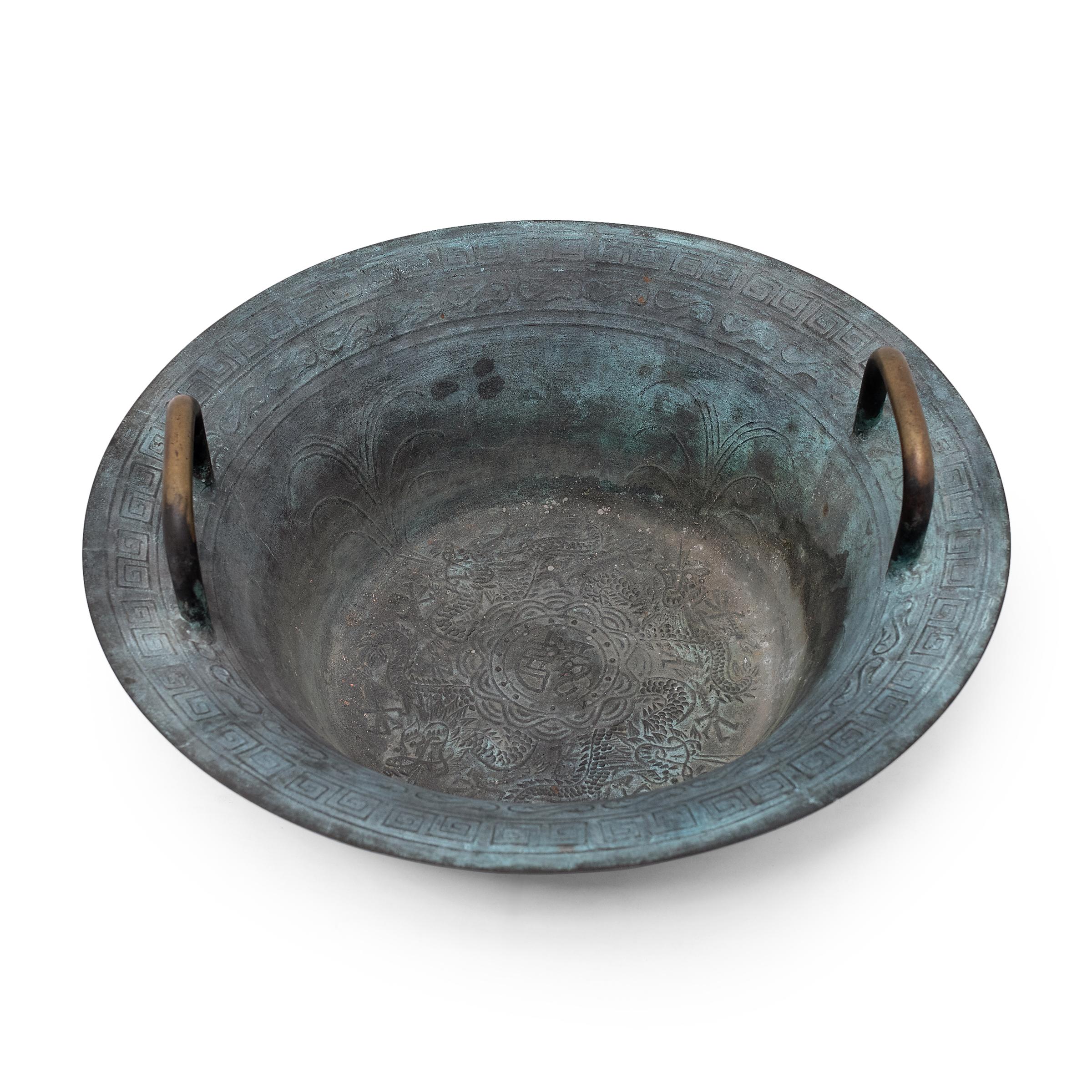 Known as a spouting bowl or resonance bowl, this brass water bowl with handles has a flared shape designed to magnify vibrations moving through its water contents. By rubbing a flat palm back and forth across the handles, the user sends vibrations