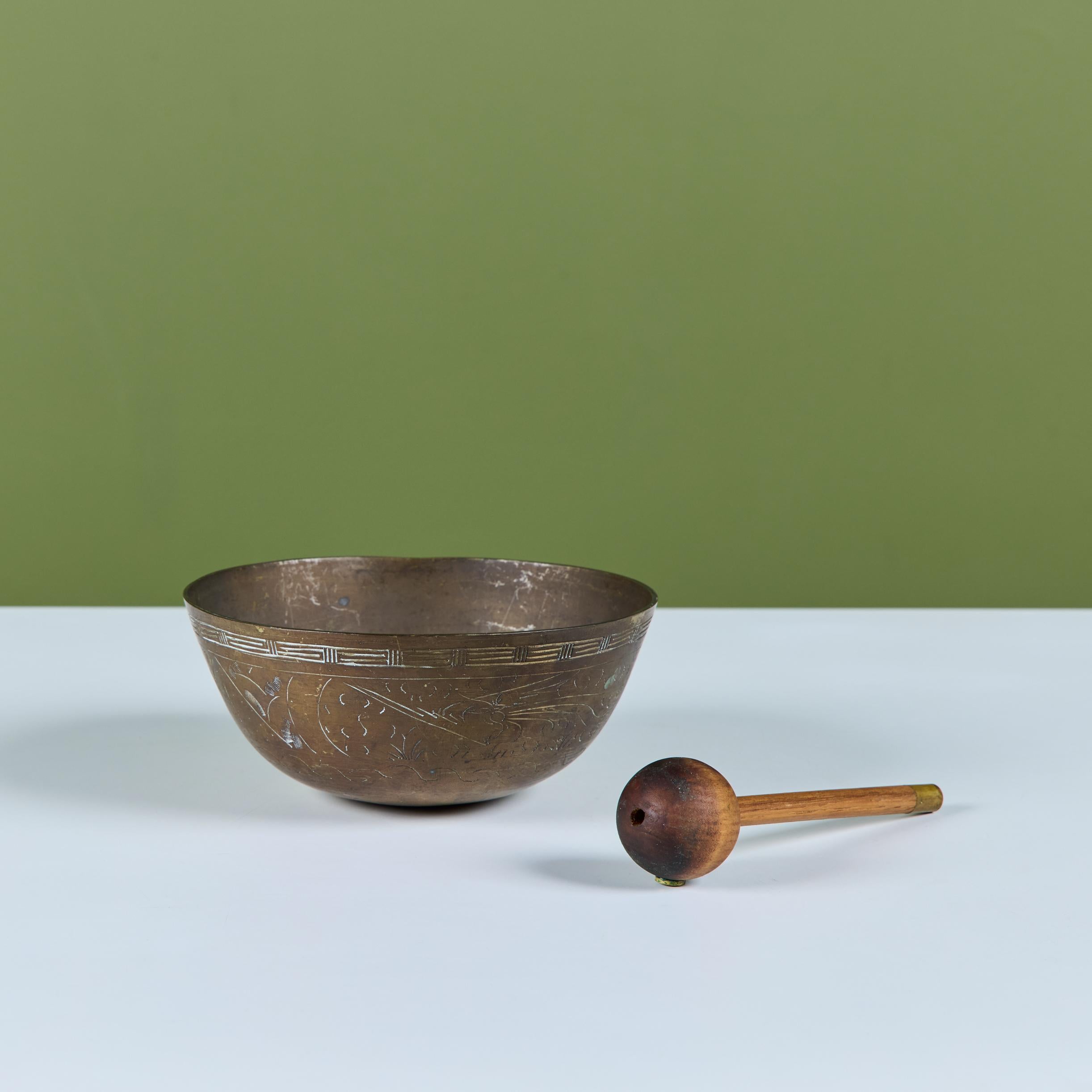 Bol chantant chinois en laiton patiné C.I.C. Le bol gravé de nuages, de vent et de scènes de montagne est accompagné d'un maillet en bois avec incrustation en laiton.

Dimensions
7,5