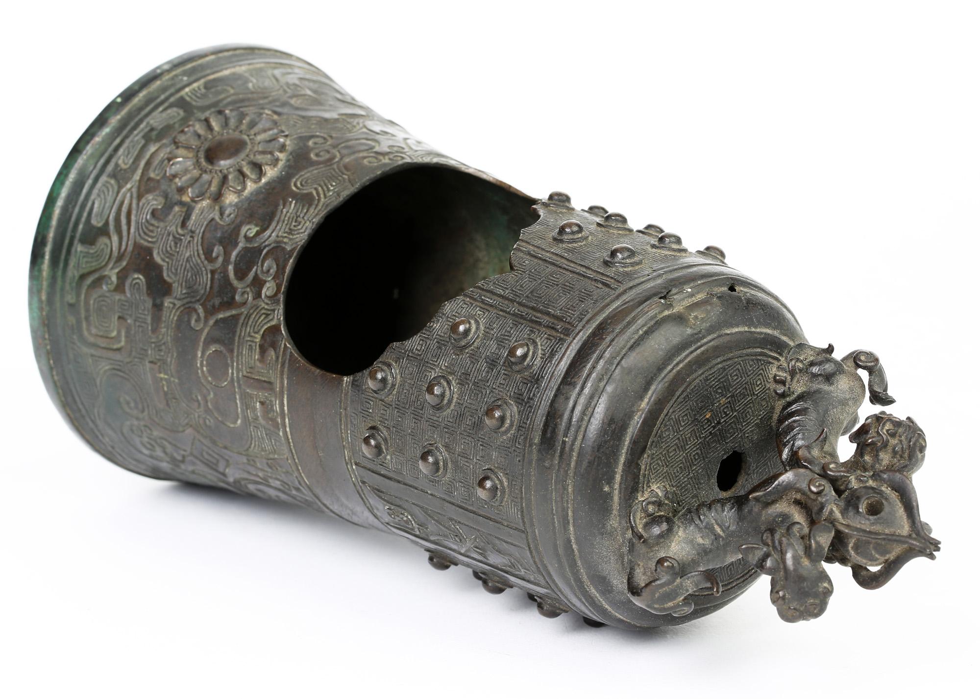 Ein ungewöhnliches chinesisches Bronzegefäß in Glockenform mit zwei buddhistischen Löwen, wahrscheinlich Ming 1368-1644. Das Räuchergefäß hat die Form einer hohlen Glocke mit breitem, abgerundetem Boden und ist mit reliefierten Taotie-Masken unter