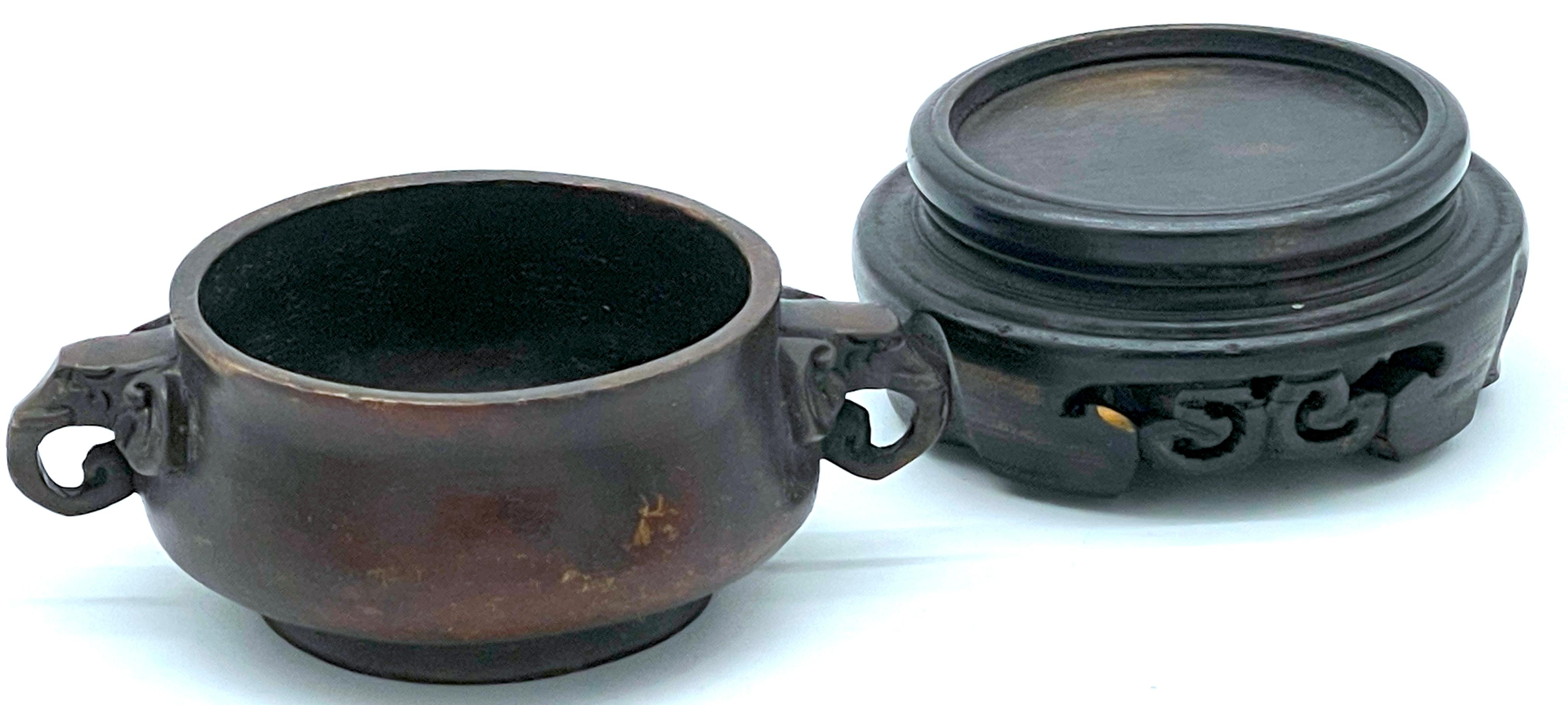 Censore cinese in bronzo con manico di elefante, firmato e con supporto in Wood intagliato, XX secolo o più antico

Questo squisito incensiere cinese in bronzo è un ottimo esempio di lavorazione tradizionale, dalla forma tipica, ornato da manici di